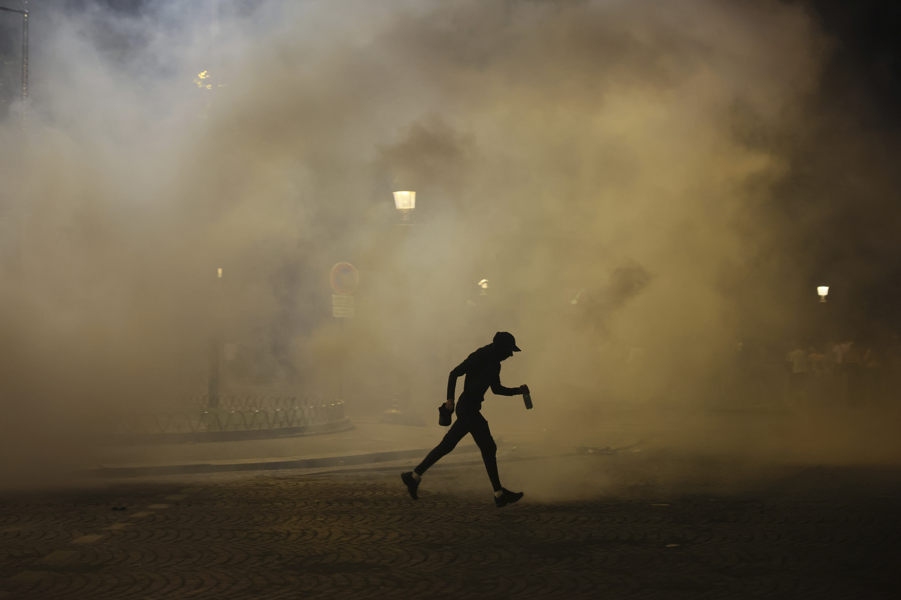 A man walks past teargas during incidents after the Champions League final soccer match between Paris Saint-Germain and Inter Milan.