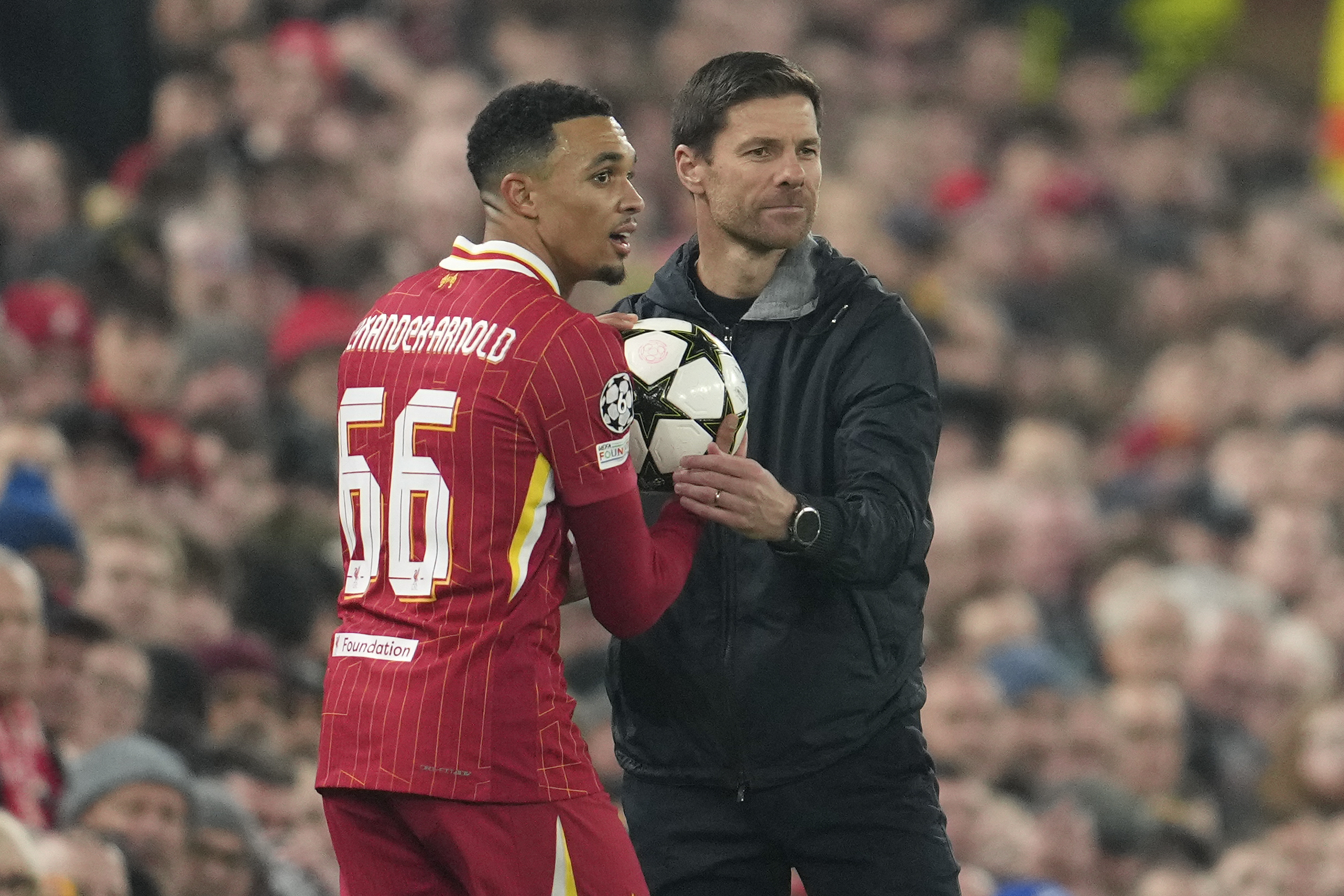 Liverpool's Trent Alexander-Arnold takes the ball from Leverkusen's head coach Xabi Alonso.