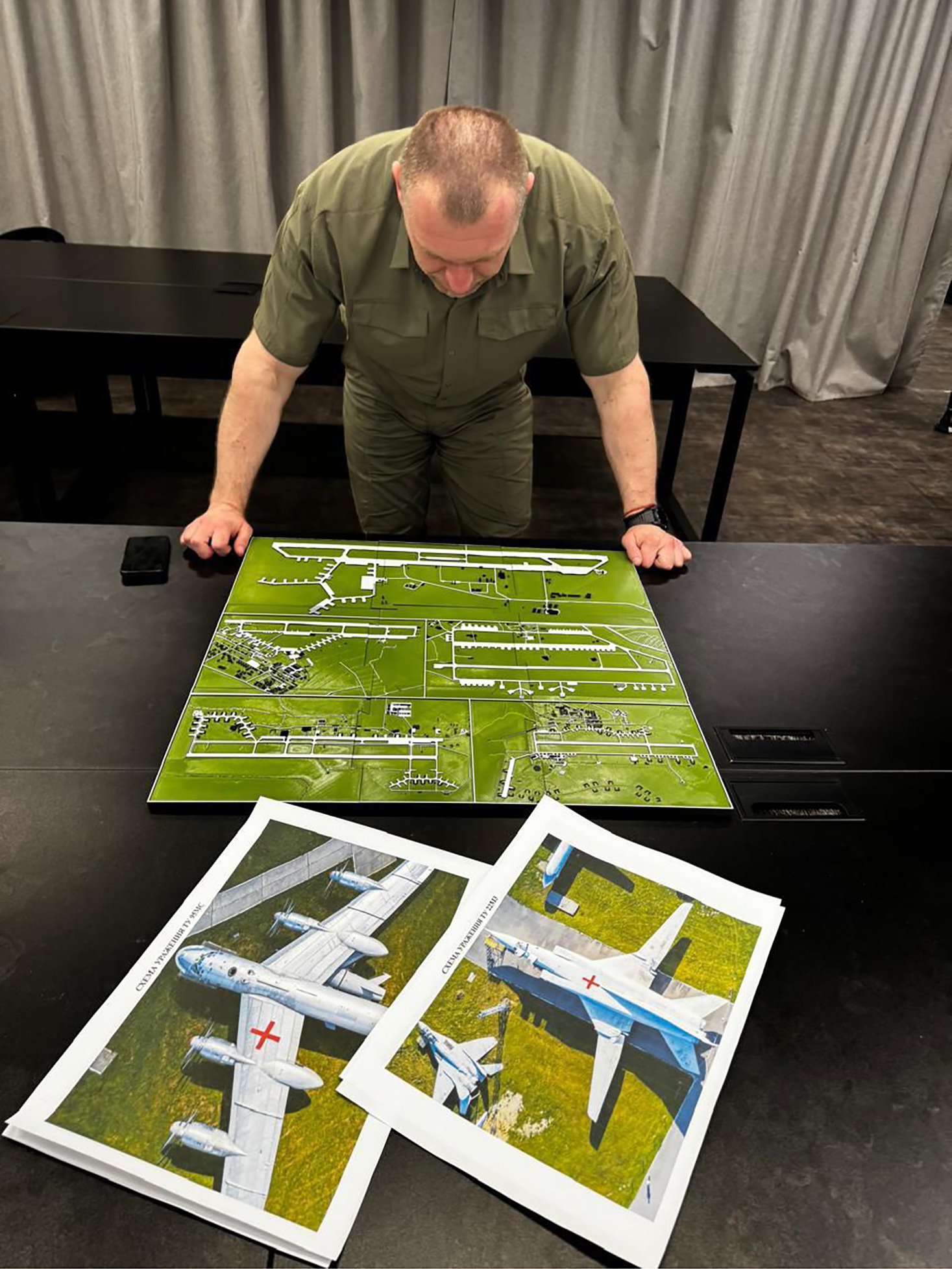 head of the Security Service studies a photo of a map of Russia's strategic aviation location in his office in Ukraine
