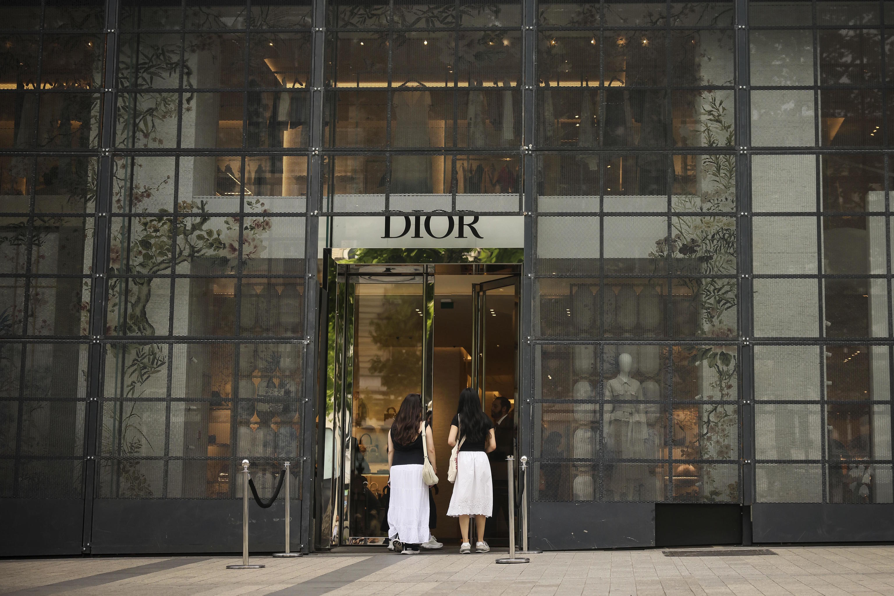 Women wait at a reinforced Dior shop.