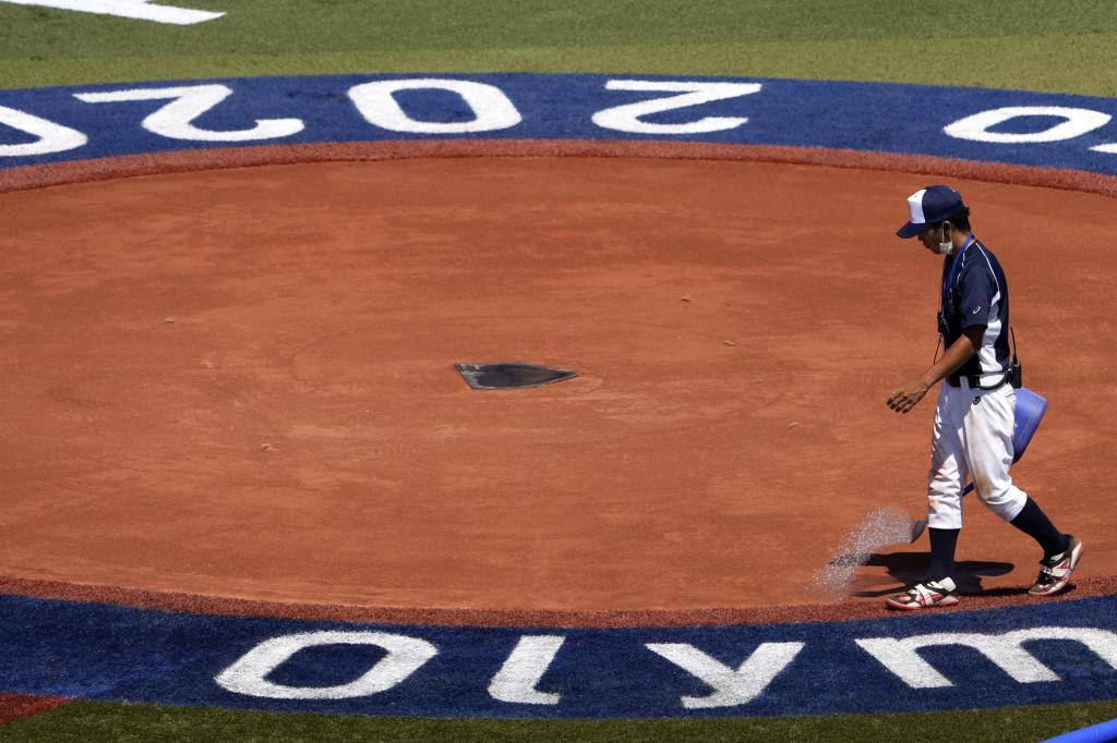 A grounds keeper works on the field before a softball practice for the 2020 Summer Olympics