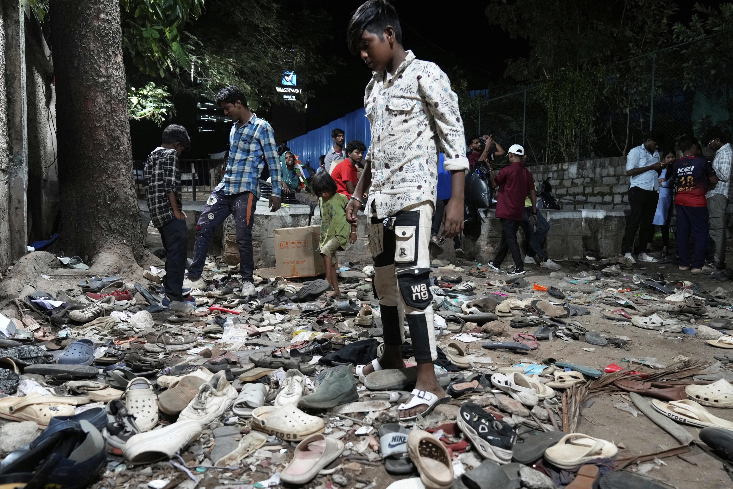 People rummage through footwear strewn outside M. Chinnaswamy Stadium.