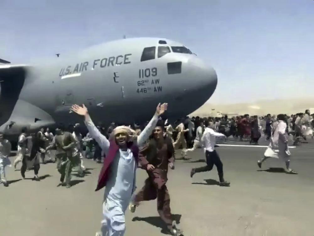 Thousands of Afghans have rushed onto the tarmac of Kabul's international airport, some so desperate to escape the Taliban capture of their country