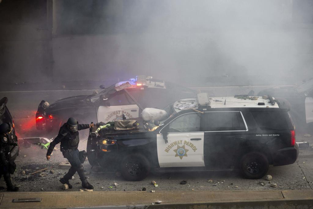 A California Highway Patrol officer pulls an electric scooter off a vehicle on a highway