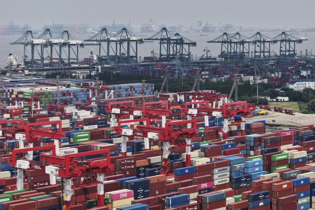 Trucks loaded with container move through a container terminal port in Shanghai, China