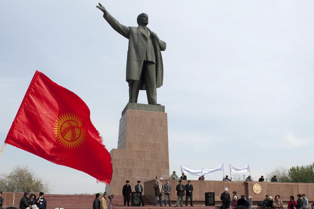 Protesters rally in front of a statue of Soviet Union founder Vladimir Lenin