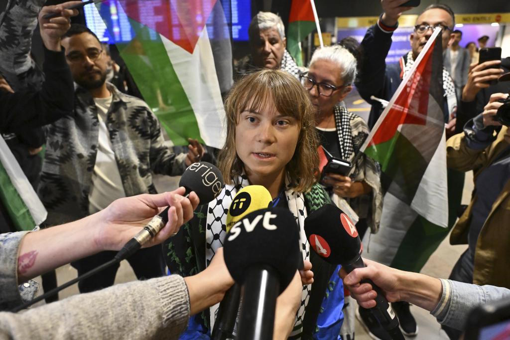 Swedish activist Greta Thunberg talks to journalists as she arrives at Stockholm,