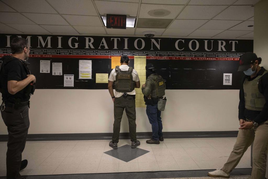 Federal agents look at court schedule at the immigration court at Jacob K. Javitz Federal Building in New York