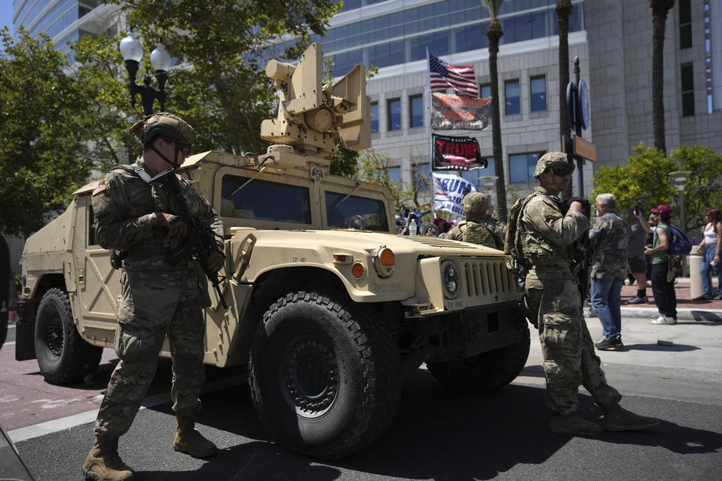 California National Guard stand guard along a street near protesters and Trump supporters in Santa Ana