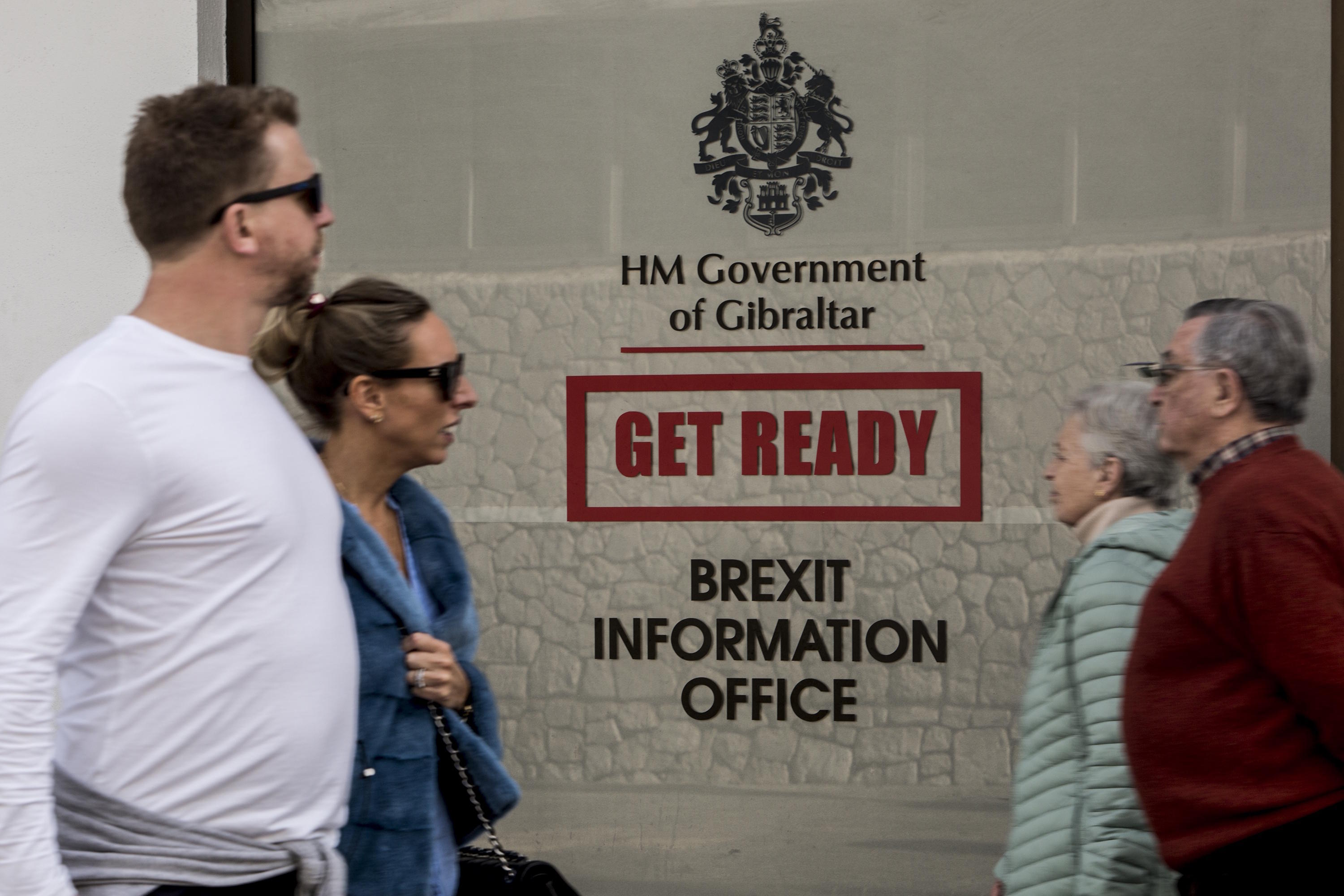 People walk past a Brexit information office at the British territory of Gibraltar.