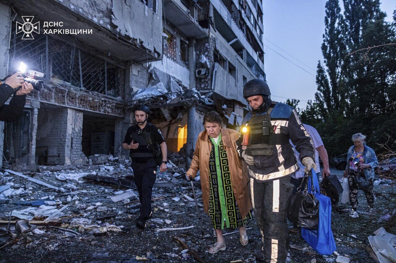 A rescue worker evacuates a woman from a building which was damaged.
