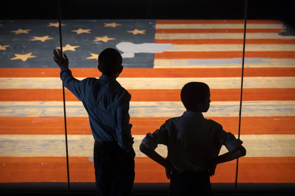 Children look at the Star Spangled Banner, the flag that inspired the lyrics of the American national anthem