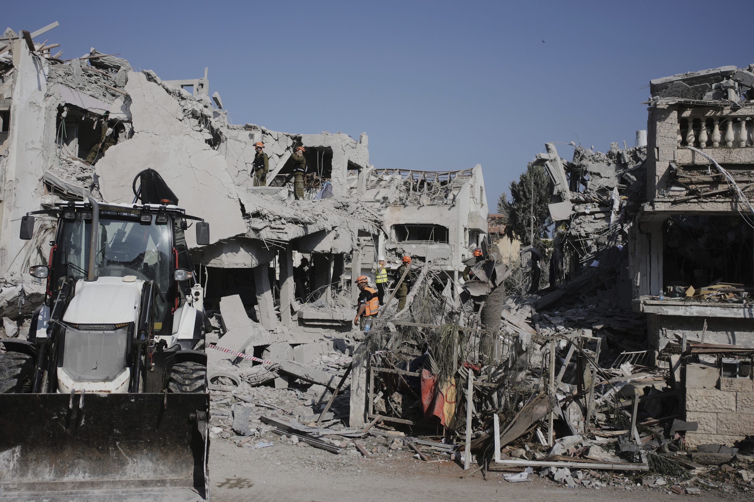 Israeli security forces inspect the site of homes destroyed by a missile fired from Iran.