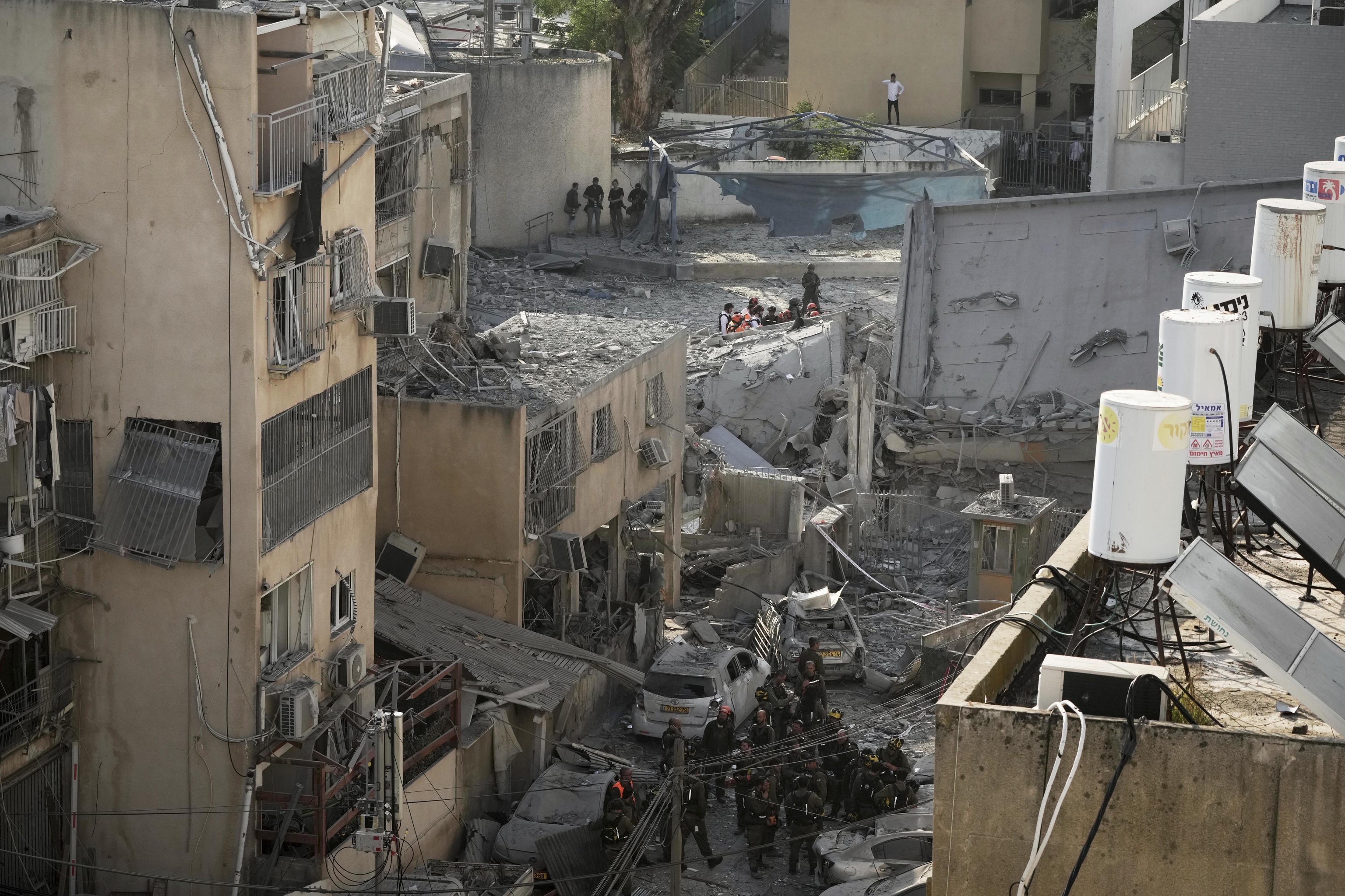 Rescue workers, police and military inspect the site where an Iranian missile struck in Bnei Brak.