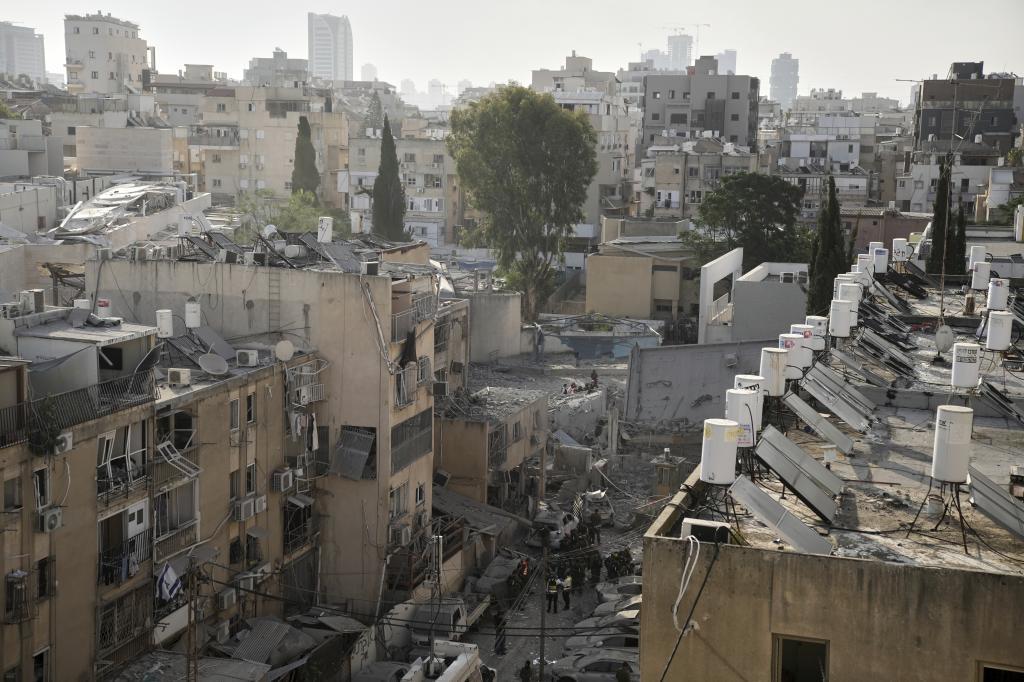 Rescue workers, police and military inspect the site where an Iranian missile struck in Bnei Brak