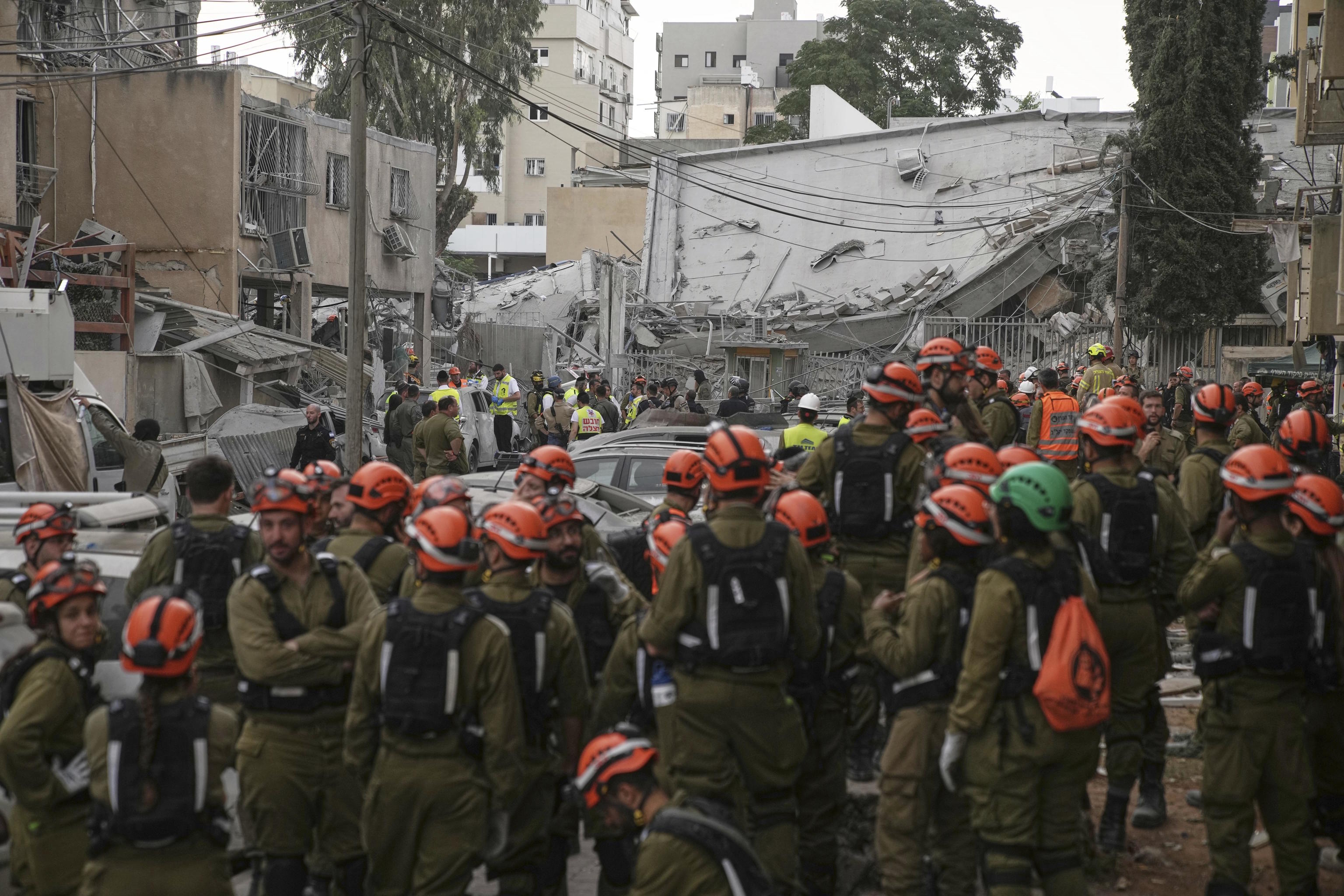 Rescue workers, police and military inspect the site where an Iranian missile struck in Bnei Brak.