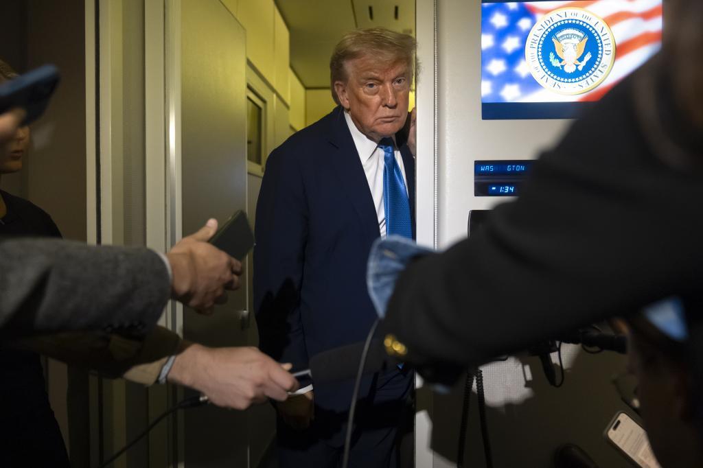 President Donald Trump speaks with reporters while flying aboard Air Force One