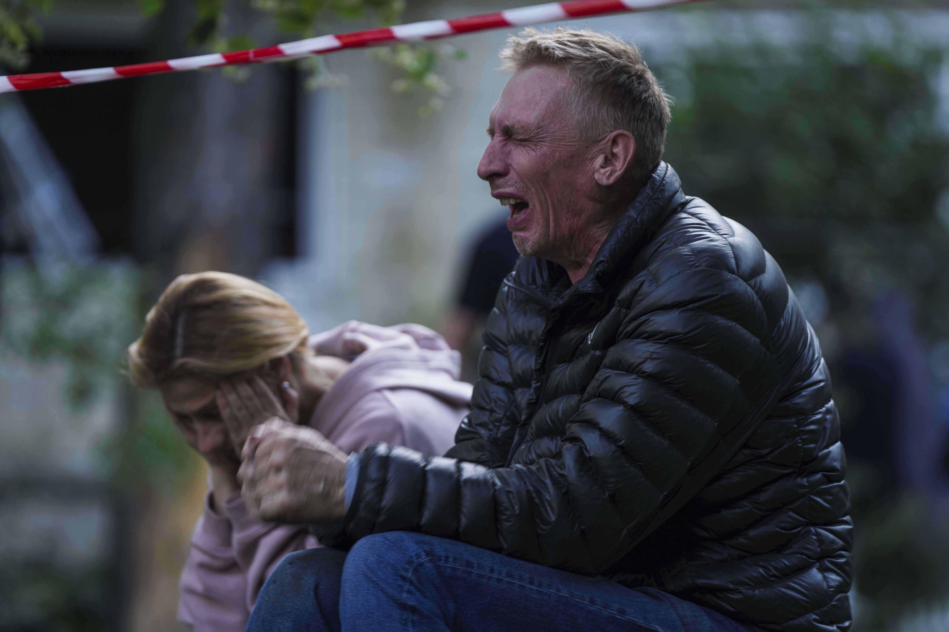 Two people cry in Kiev after the devastating Russian attack on the Ukrainian capital.
