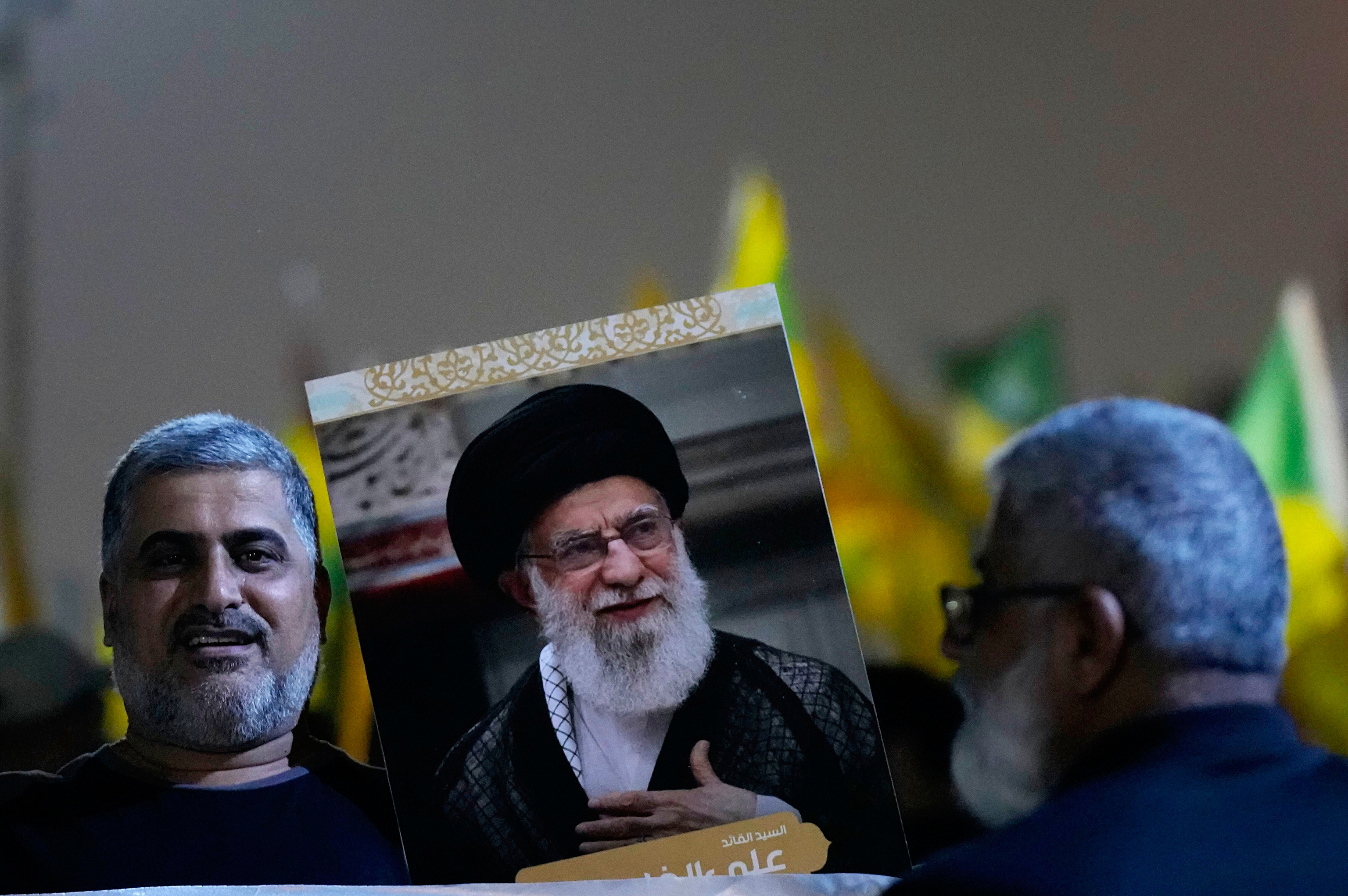 A protester holds a portrait of Iran's Supreme Leader Ayatollah Ali Khamenei.