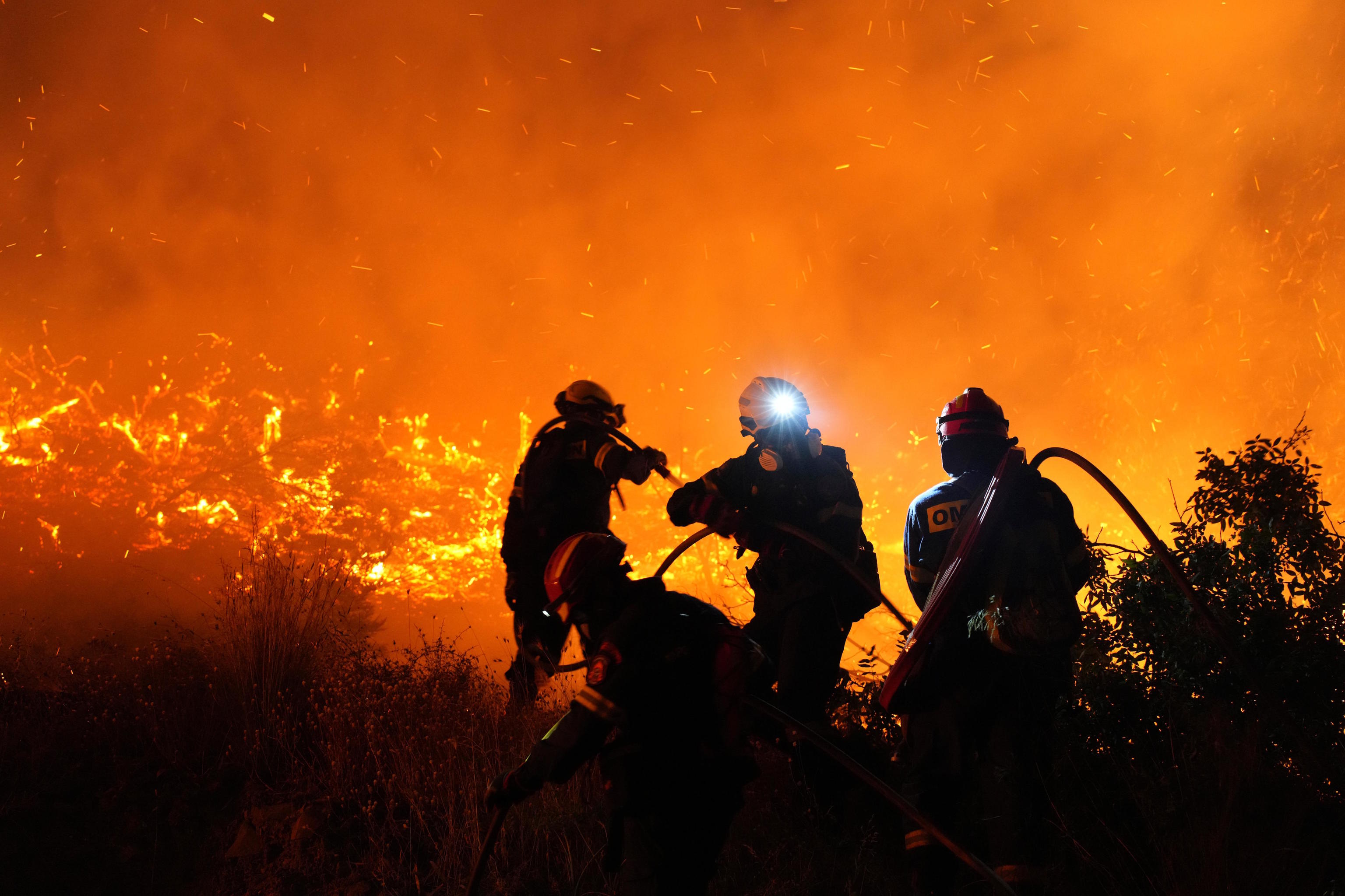 Firefighters battle with a large wildfire burning in Kofinas.