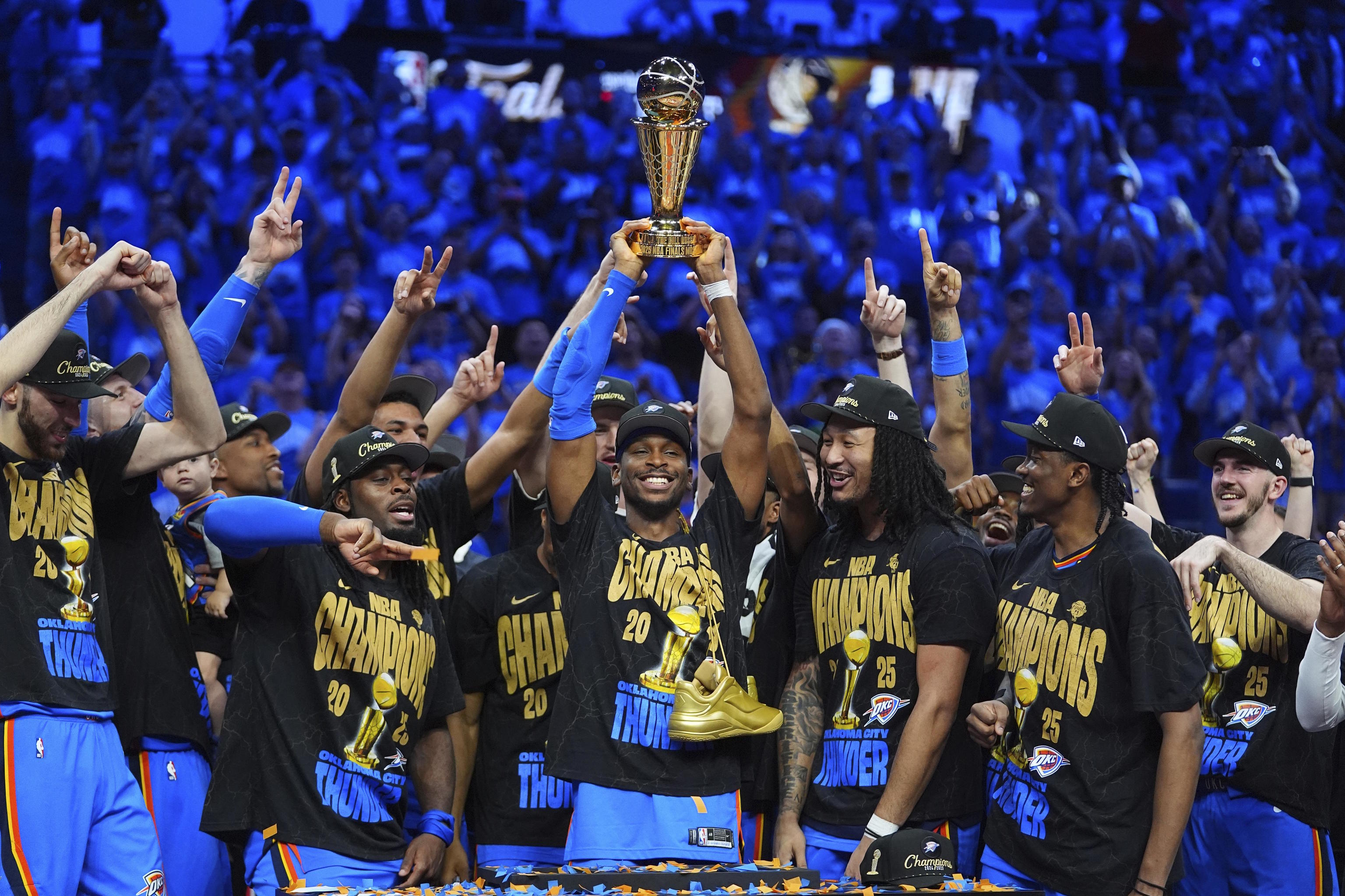 Oklahoma City Thunder guard Gilgeous-Alexander, center, holds up the MVP trophy.