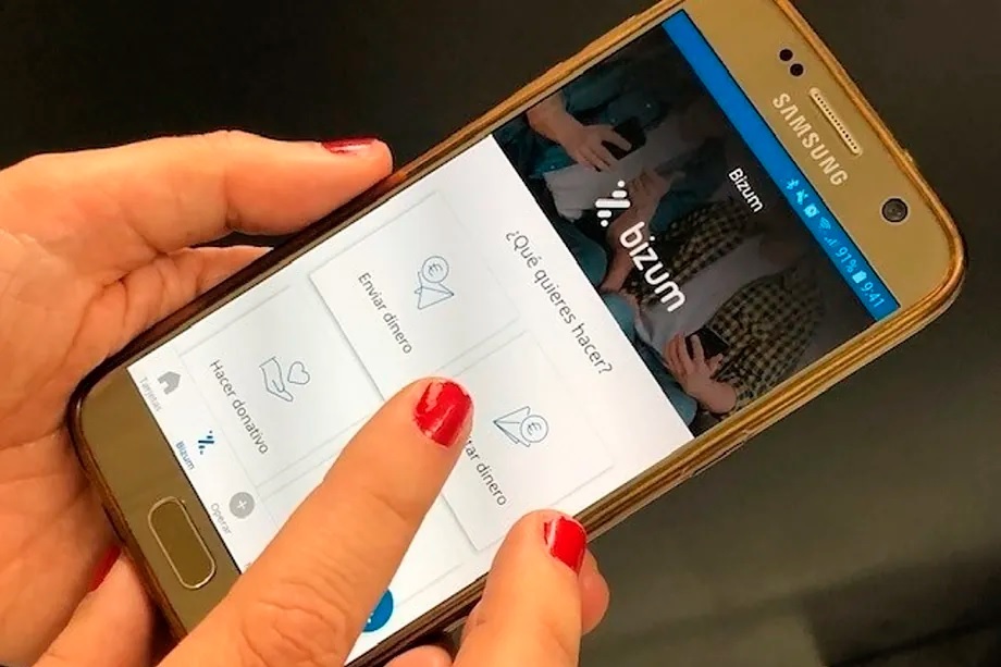 A person makes a transaction with Bizum on their mobile phone.