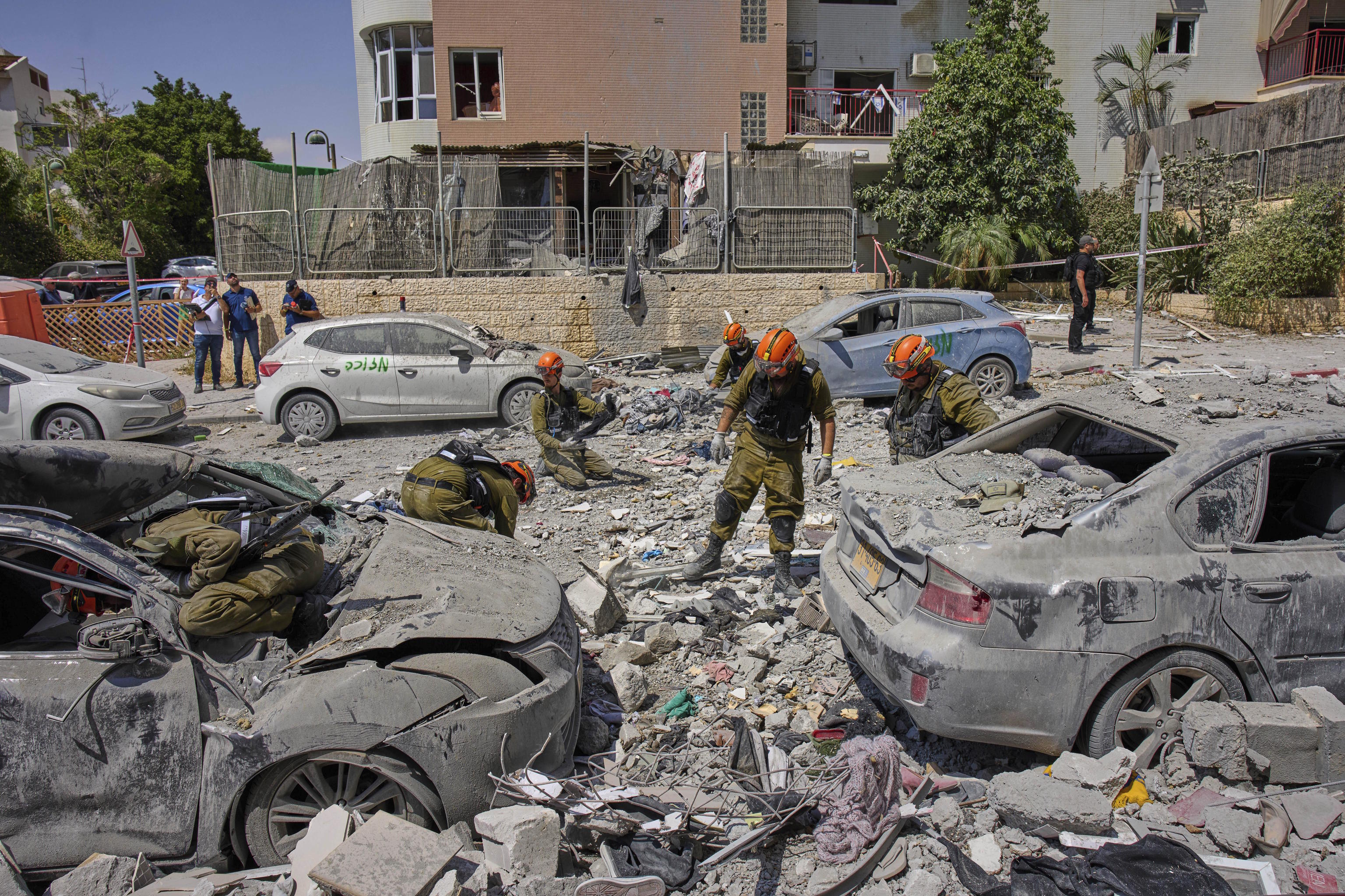 Israeli soldiers work amid the rubble of residential buildings destroyed by an Iranian missile strike.