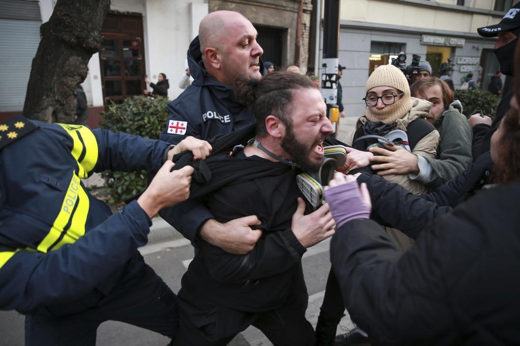 Police detain a protester during a rally against the results of the parliamentary election in Tbilisi