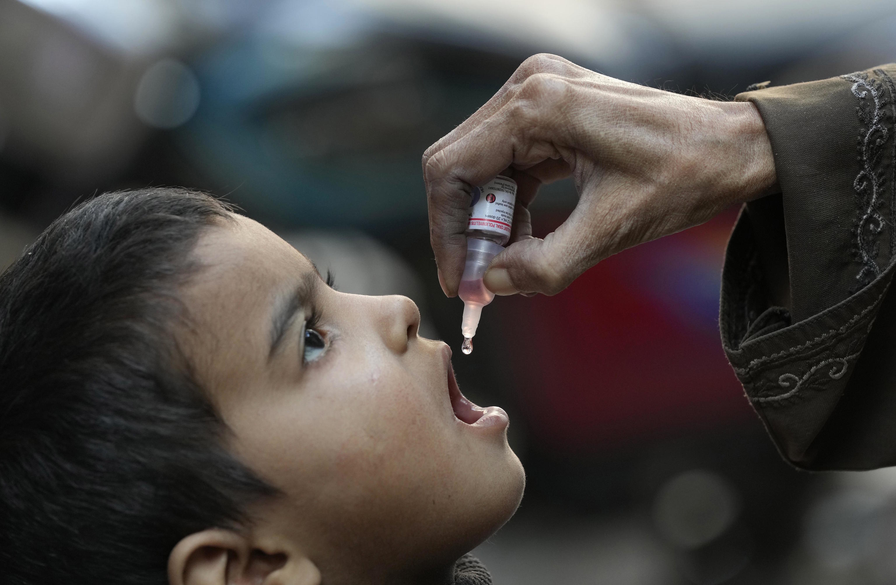 A health worker administers a polio vaccine to a child in Karachi, Pakistan.