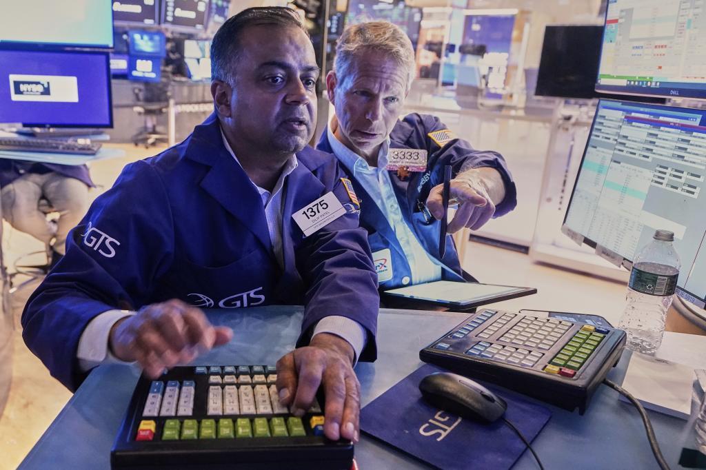 Specialist Dilip Patel, left, and stockbroker Robert Charmak work on the trading floor of the New York Stock Exchange.
