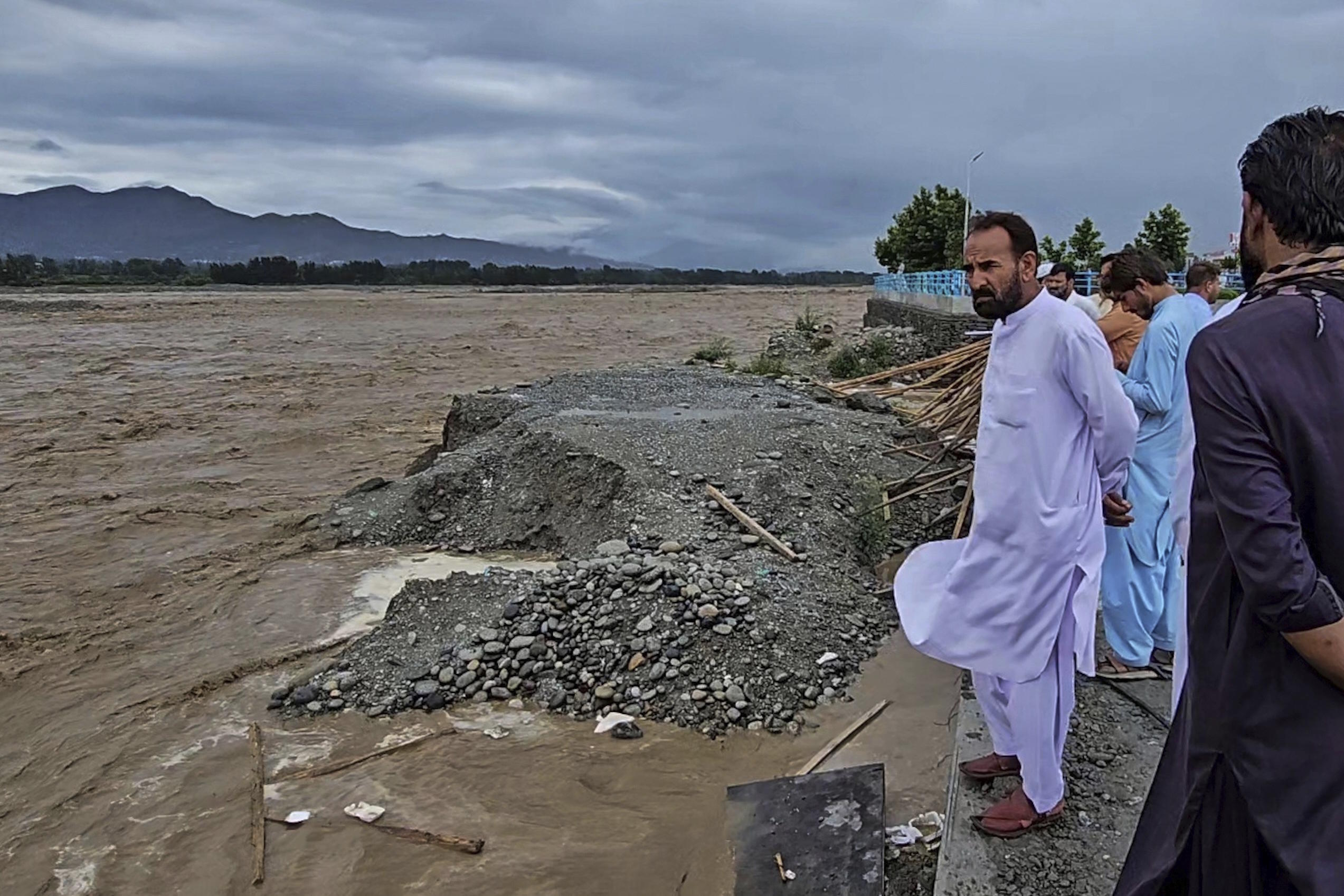 Local residents look to the Swat River, which is overflowing due to pre-monsoon heavy rains in the area.