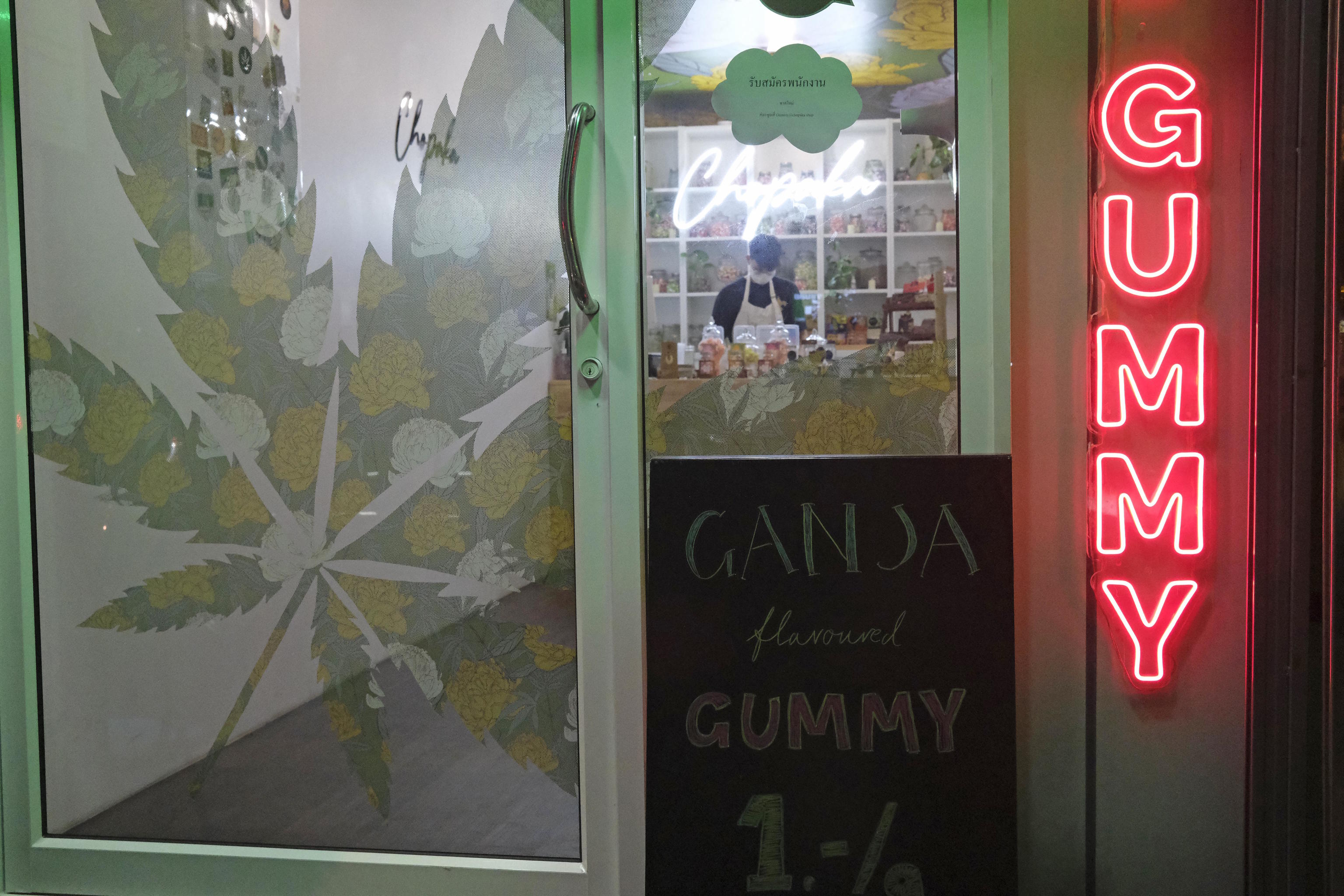 Pedestrians pass by a newly-legal cannabis shop in Bangkok.
