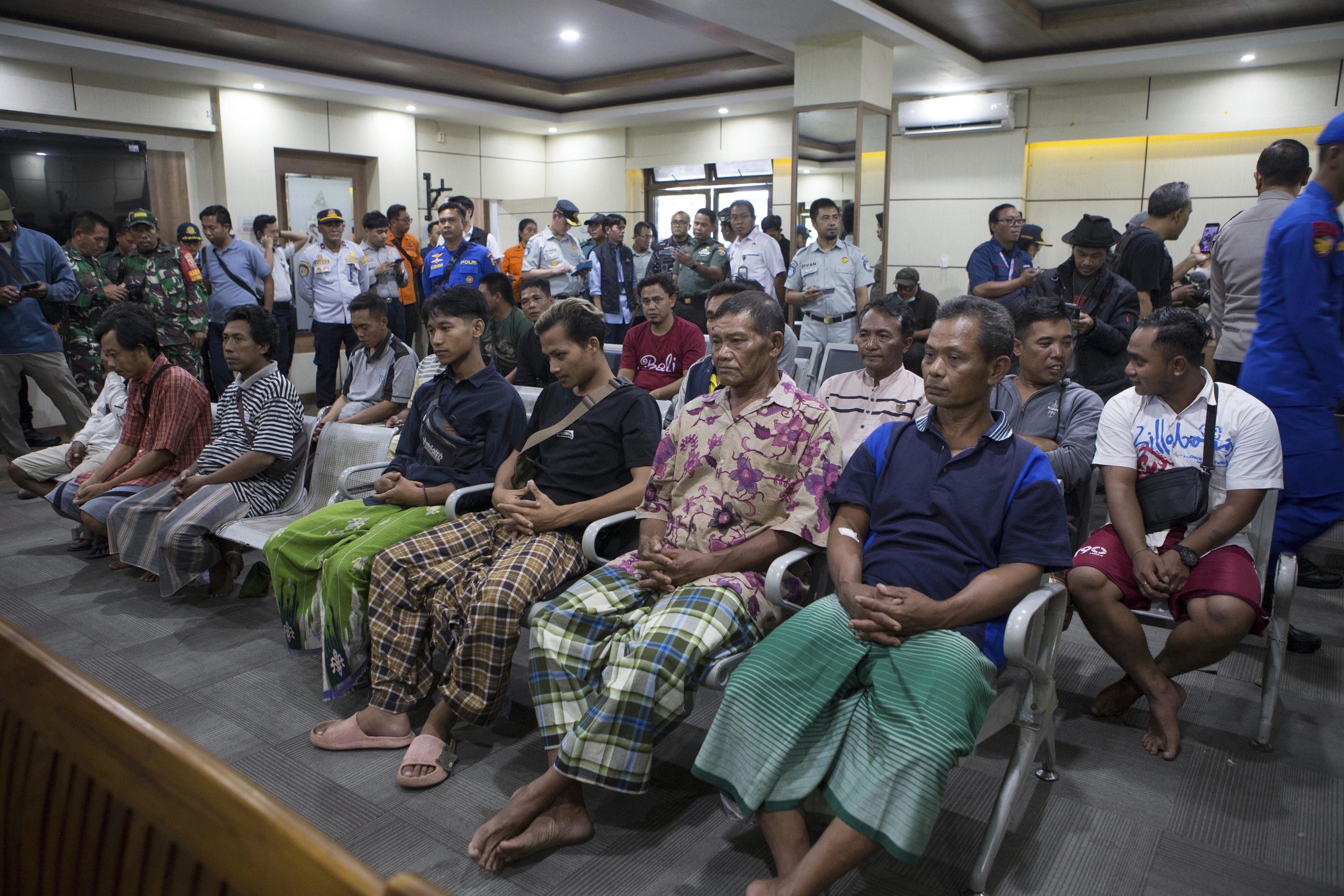 Survivors rescued after a ferry sank wait for a health examination on Bali island.