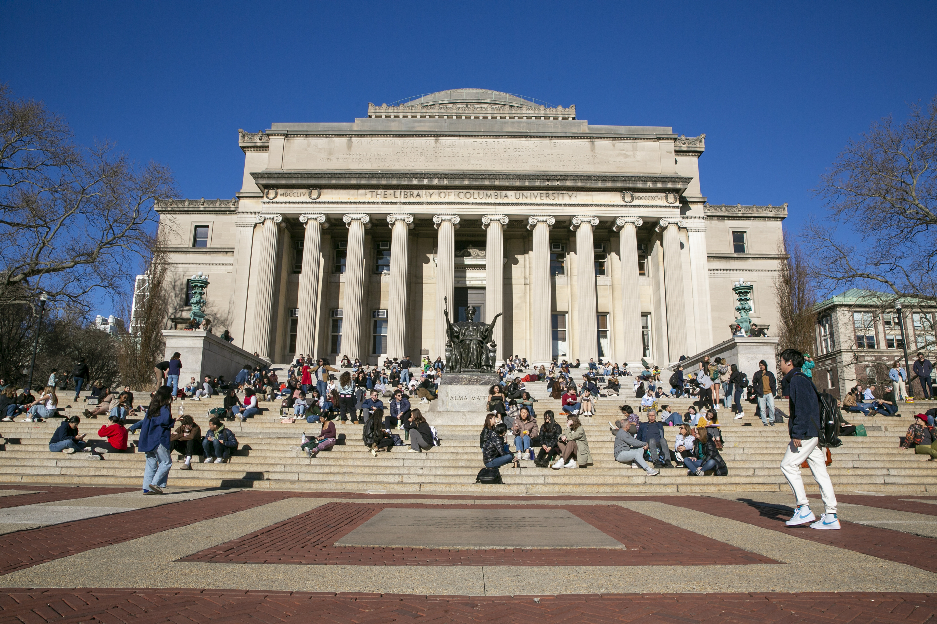 Students sit on the front steps of Low Memorial Library on the Columbia University campus.