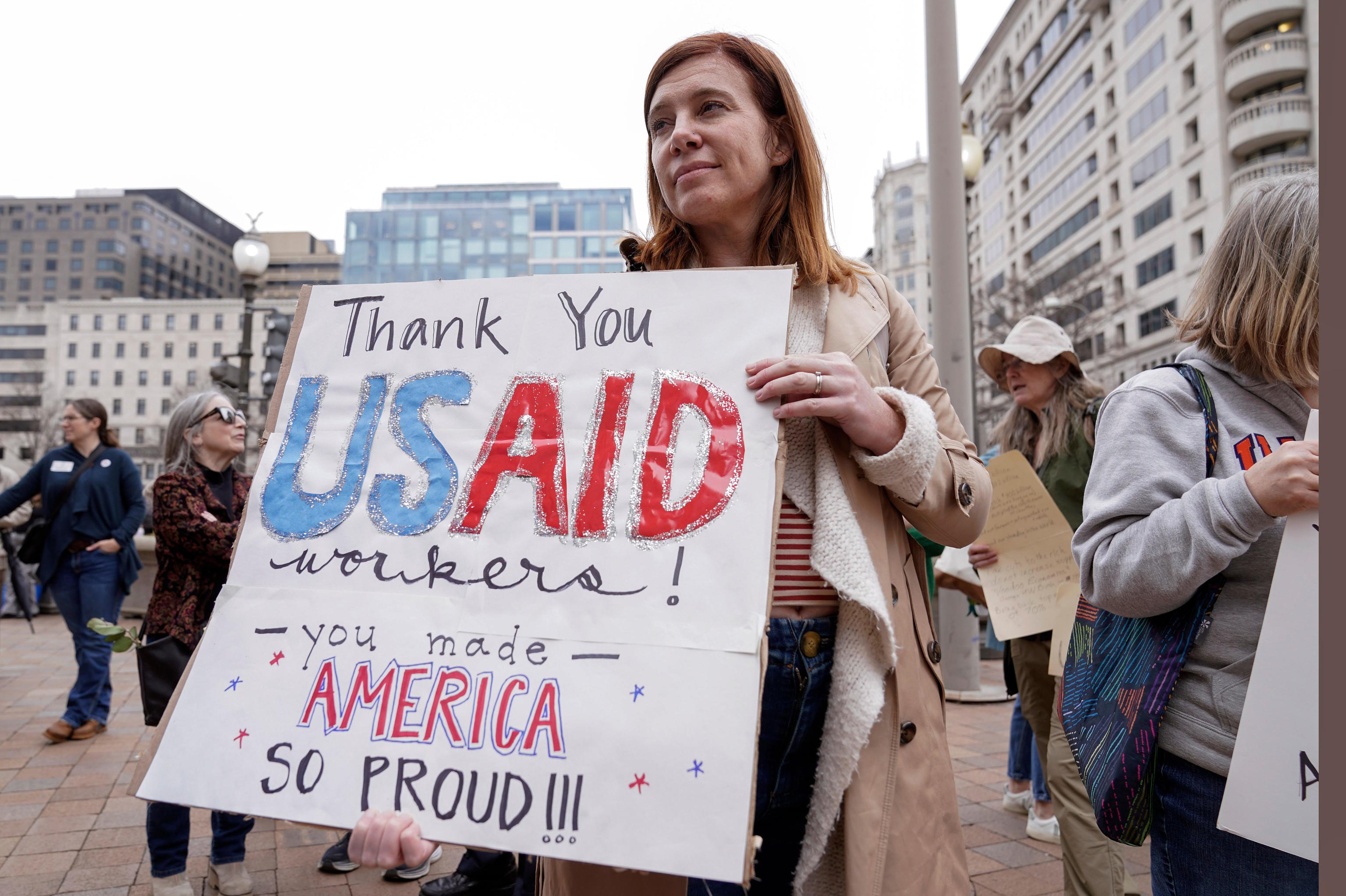 A person carries a sign in support for USAID workers.