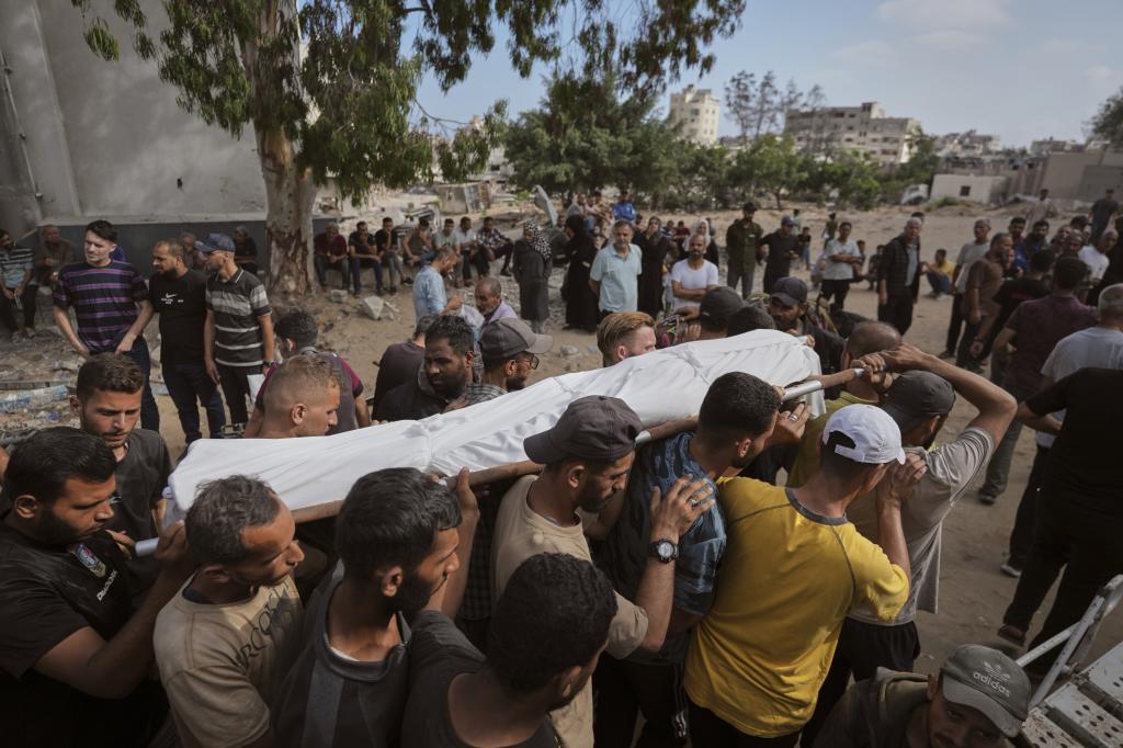 Mourners carry the body of a Palestinian man killed while heading to an aid distribution hub