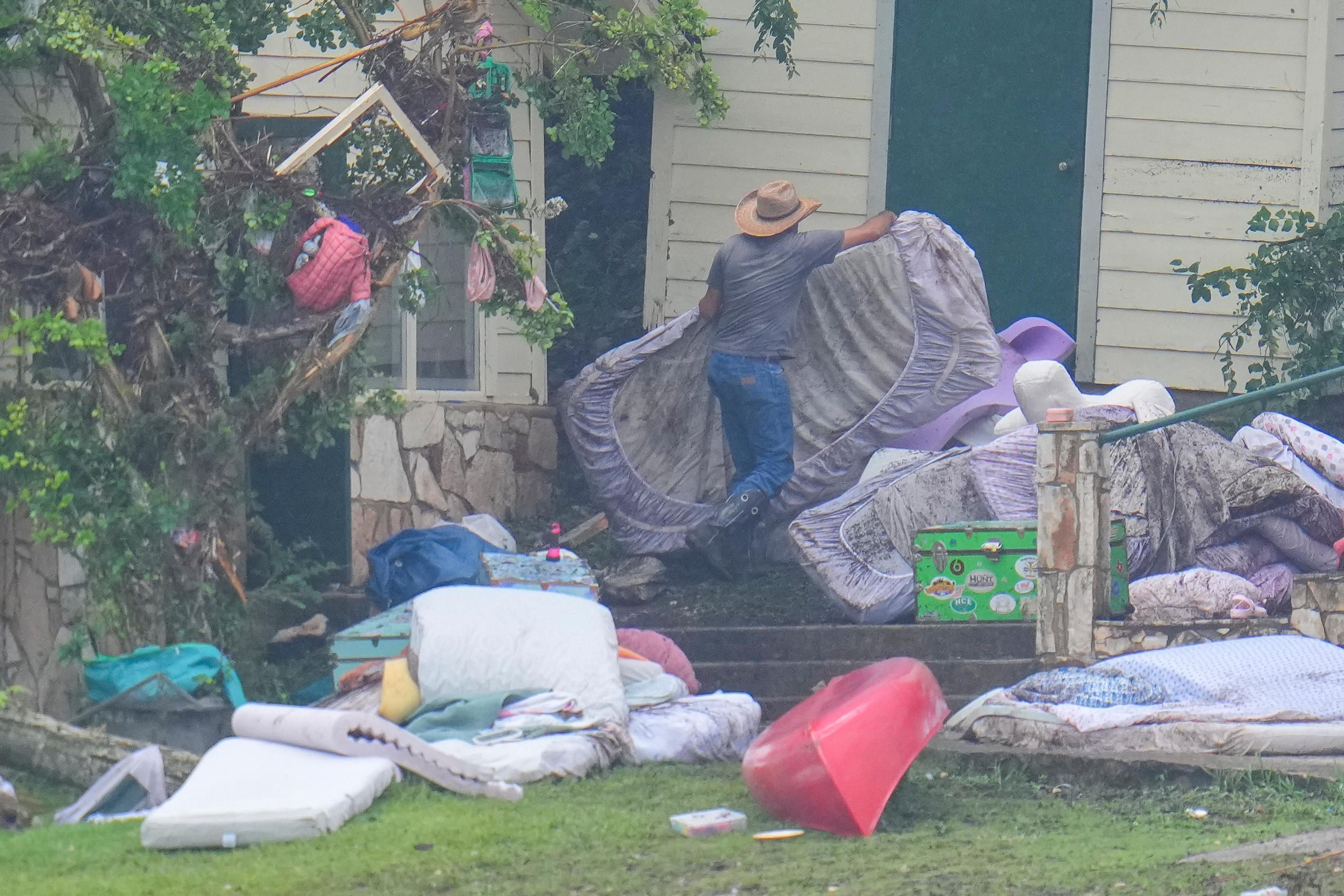 A person removes bedding from sleeping quarters at Camp Mystic.