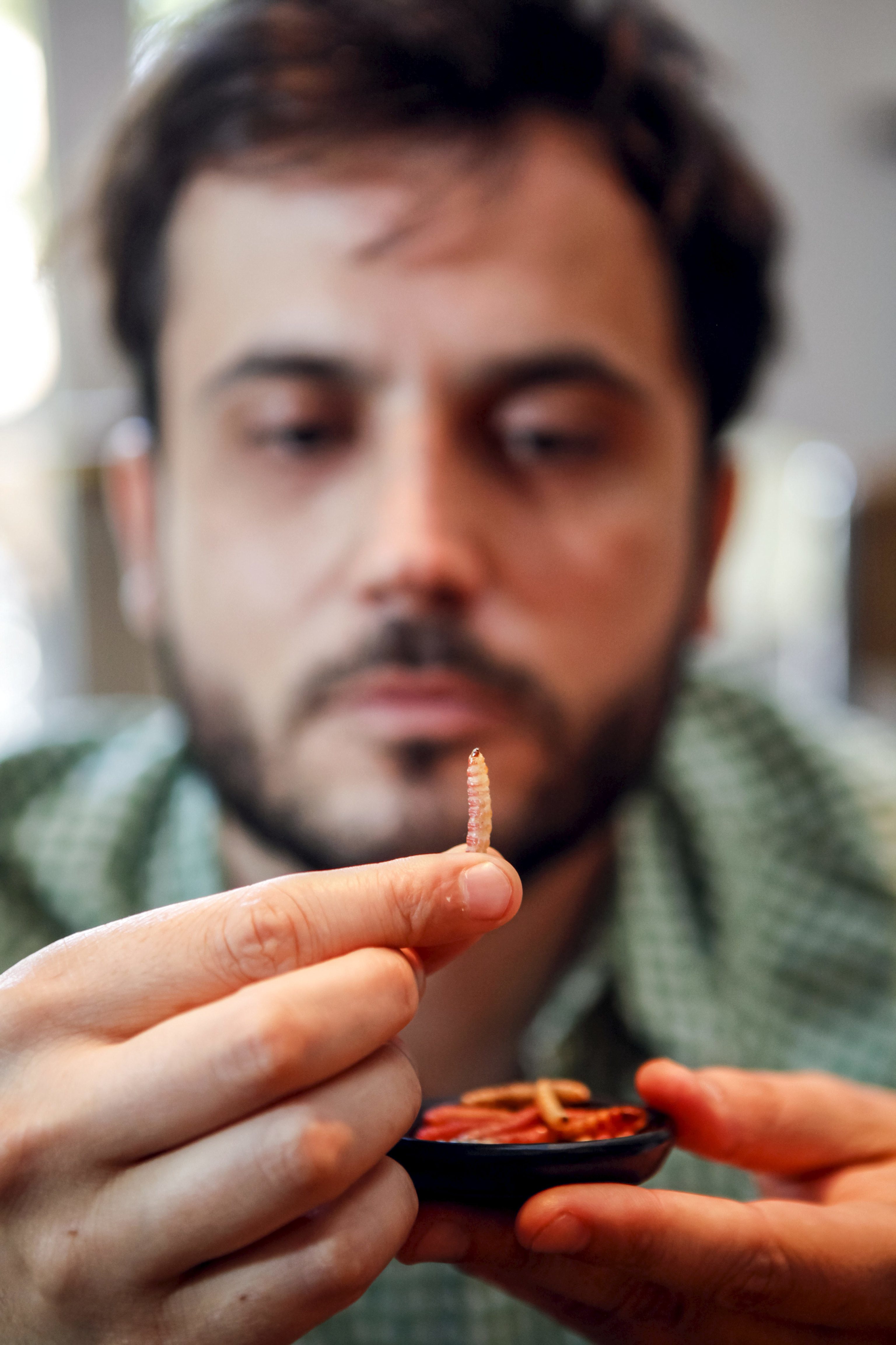 A man holds a worm.