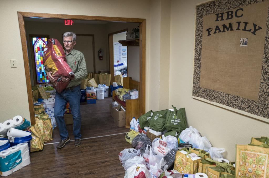 Pastor John Collis, carries in a donated bag of dog food at Hunt Baptist Church