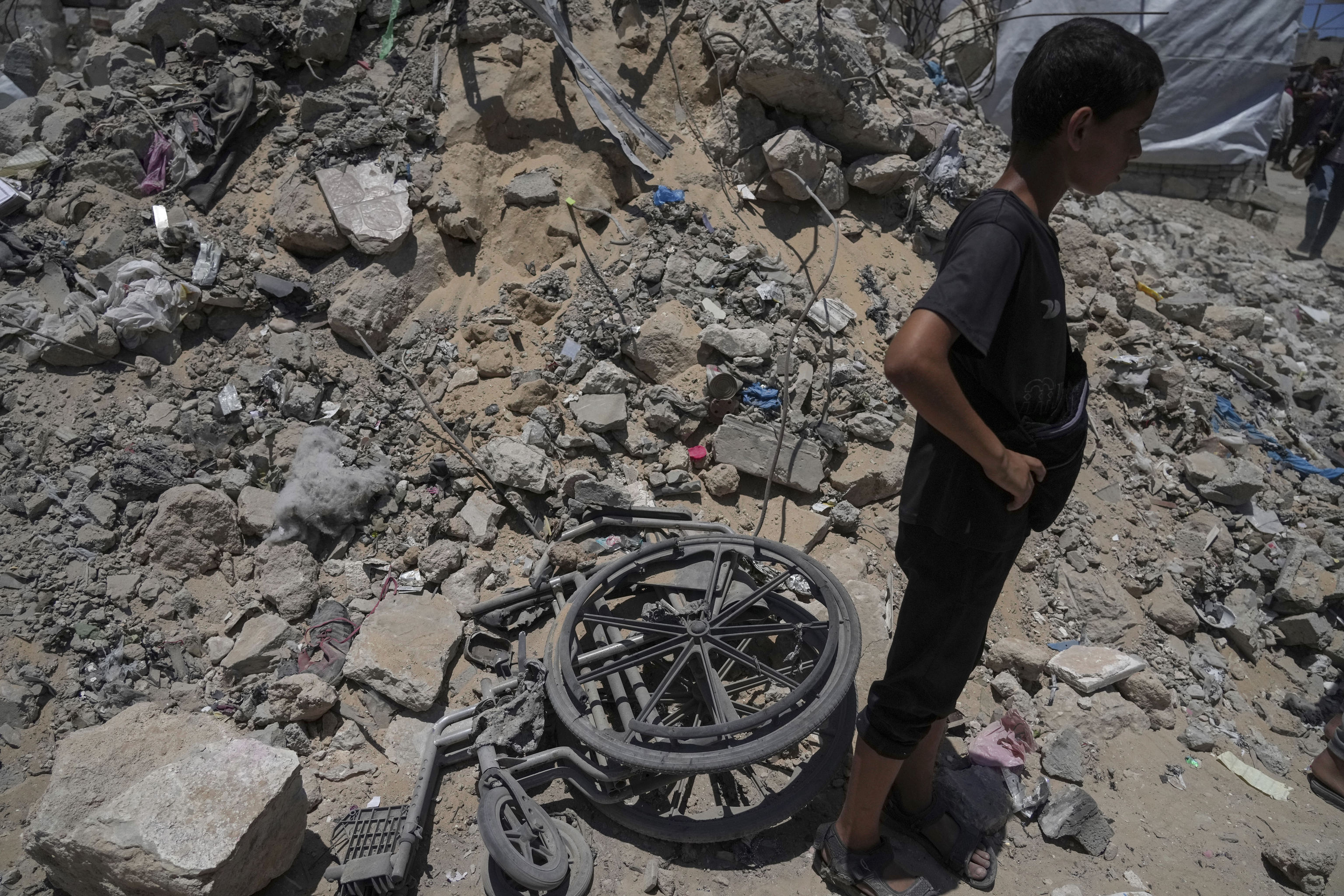 A kid stands next to the rubbles following an Israeli strike.