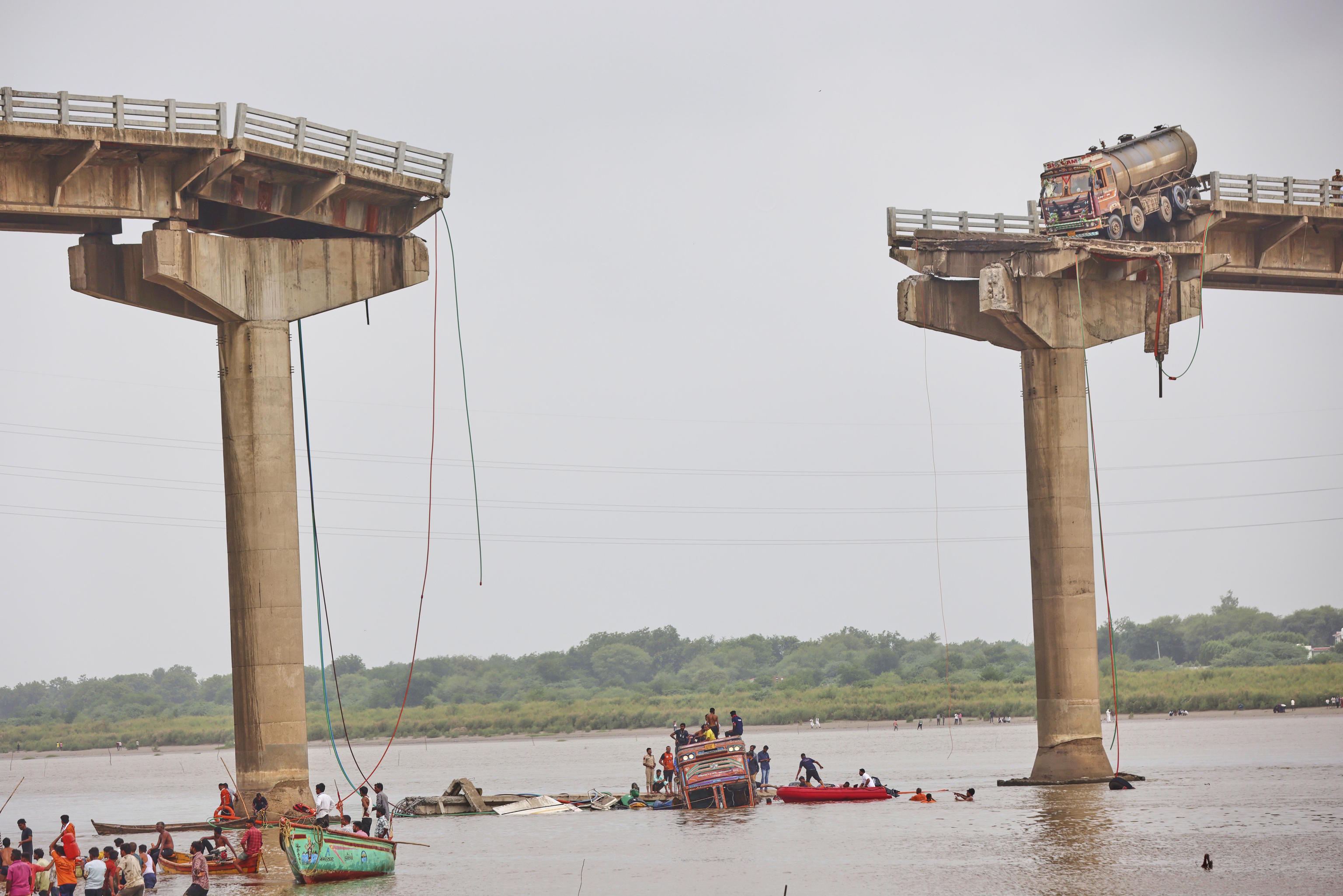 Rescuers search for survivors after a section of a bridge collapsed in Mujpur.