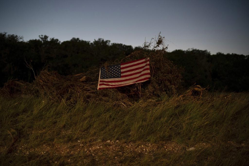 An American flag hangs on debris near Camp Mystic.