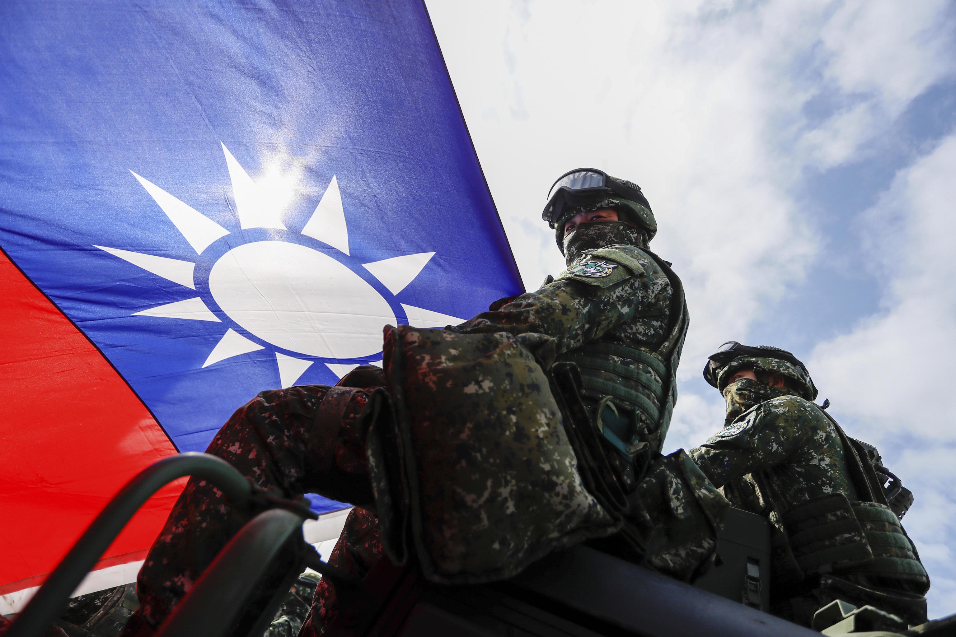 Soldiers holding a Taiwanese flag.