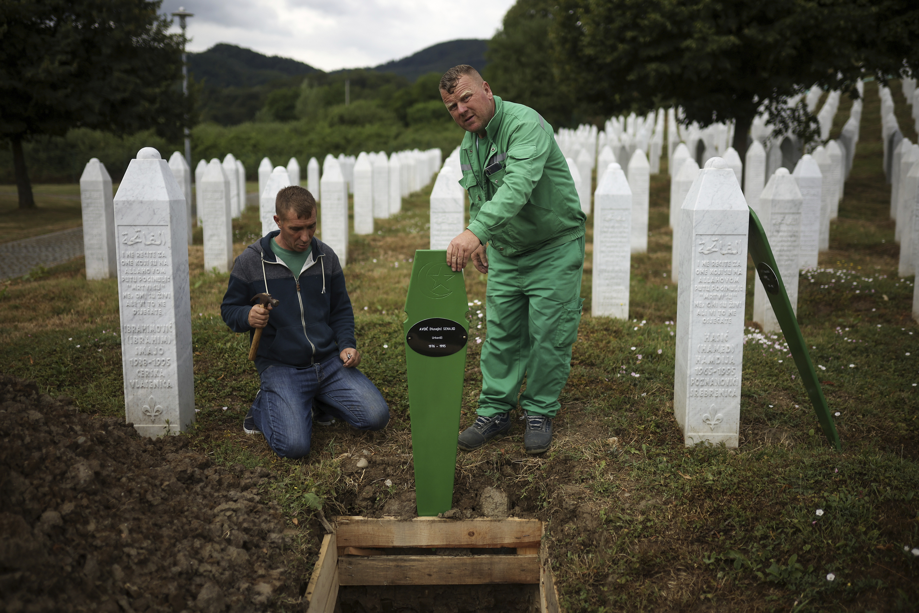 Cemetery workers prepare the graves for a mass burial.