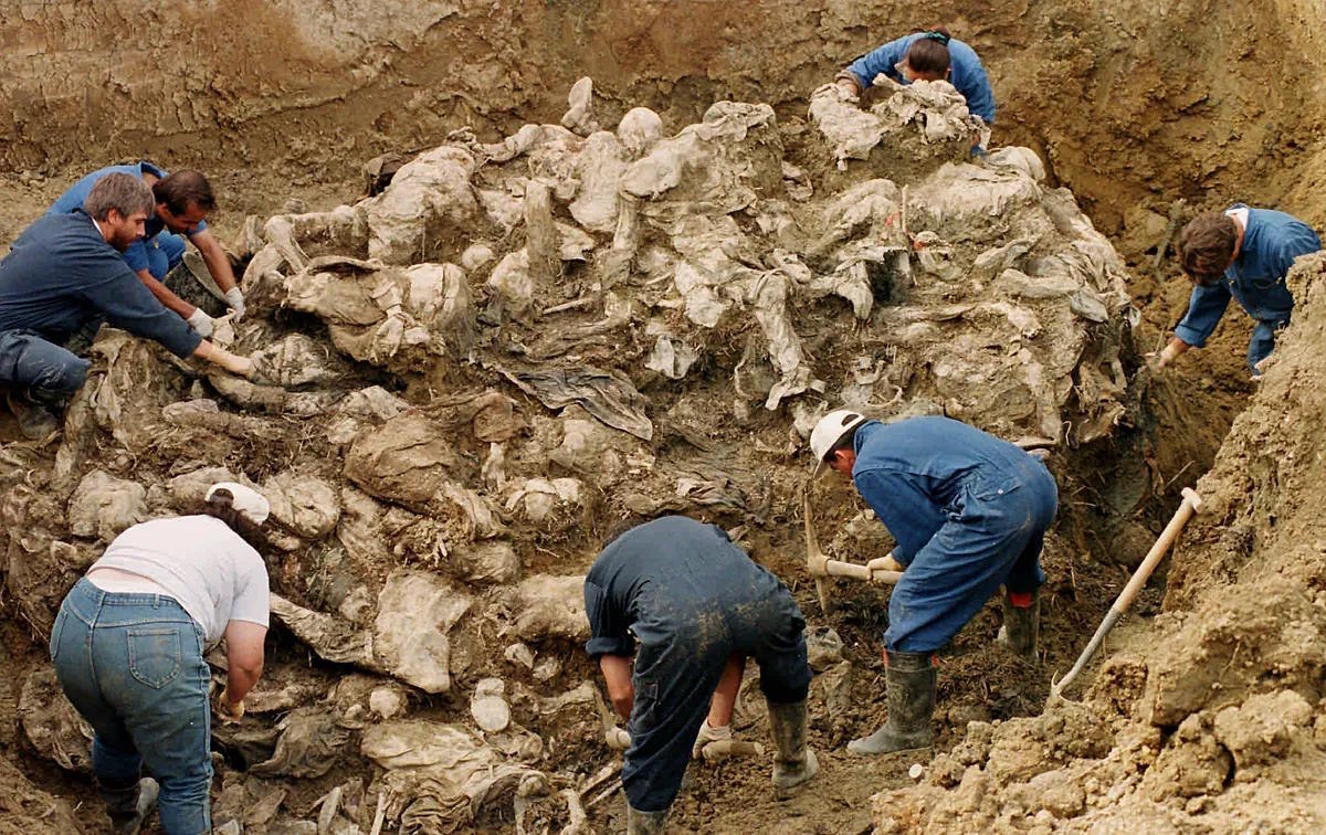 War Crimes Tribunal investigators clean the soil and debris of dozens of Srebrenica victims.