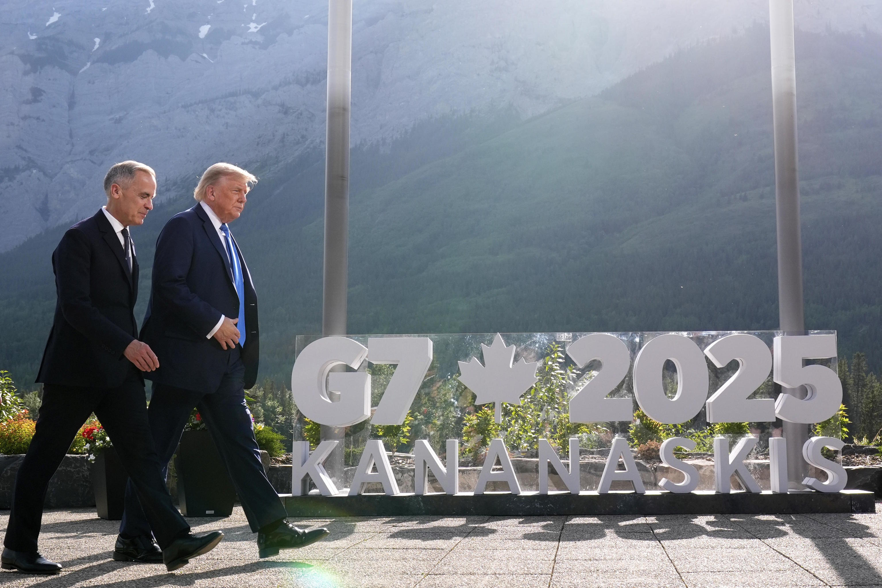Canadian Prime Minister Mark Carney walks alongside U.S. President Trump.