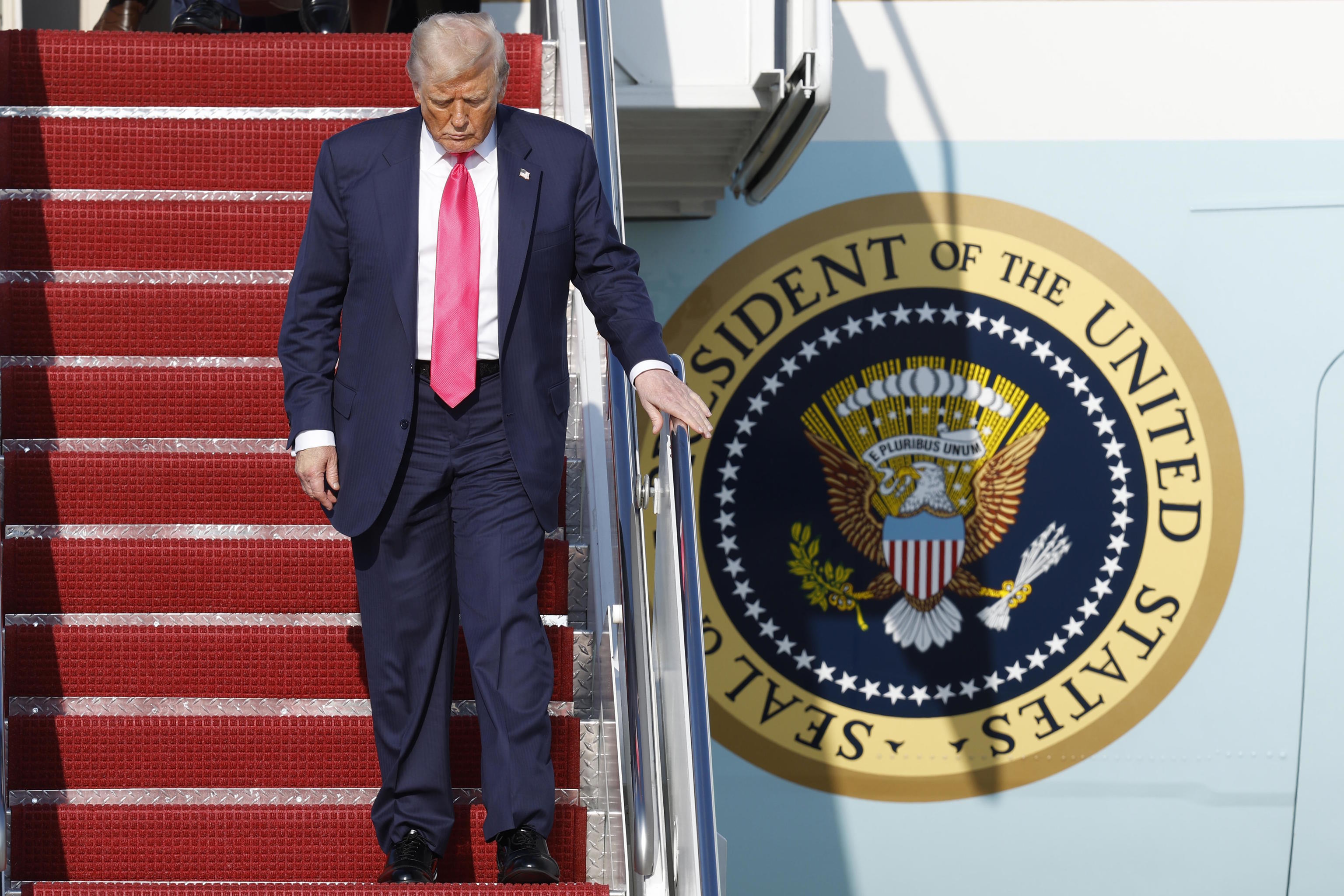 Donald Trump walks down the stairs of Air Force One.