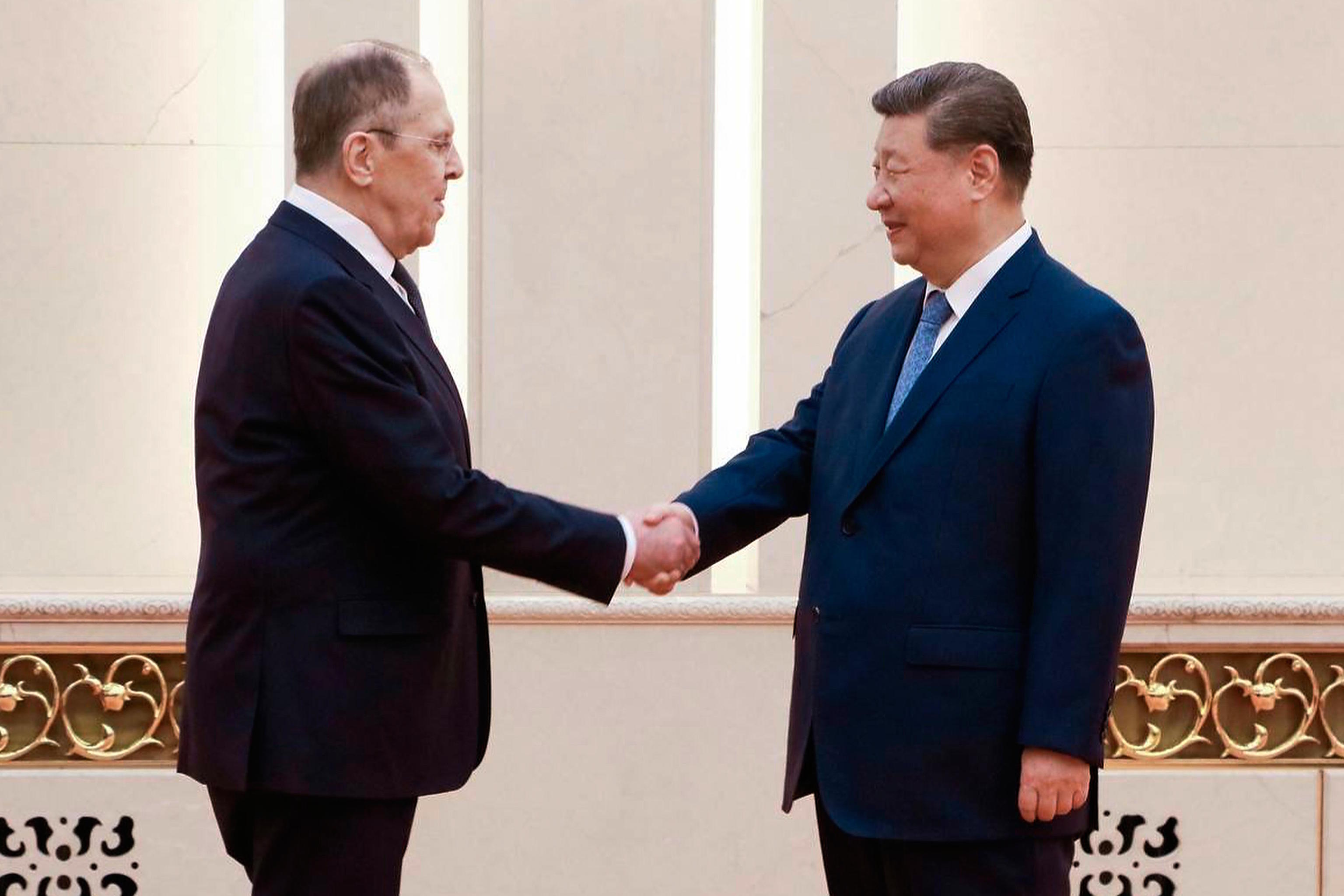 Chinese President Xi Jinping greets Russian Foreign Minister Sergei Lavrov.