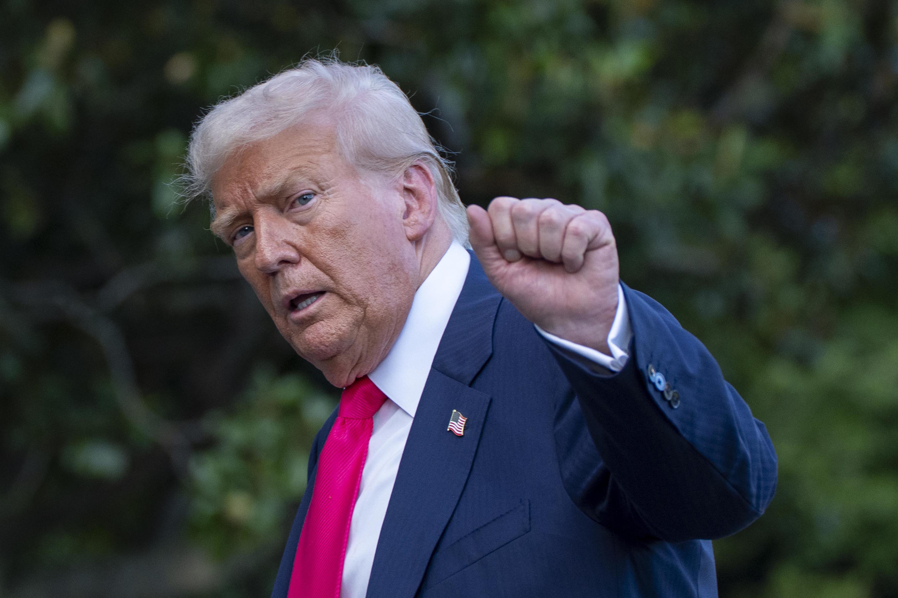 US President Donald Trump responds to the media at the White House.