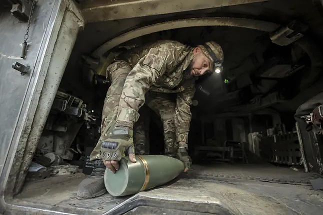 A soldier prepares to fire a shell towards Russian army positions near Chasiv Yar.